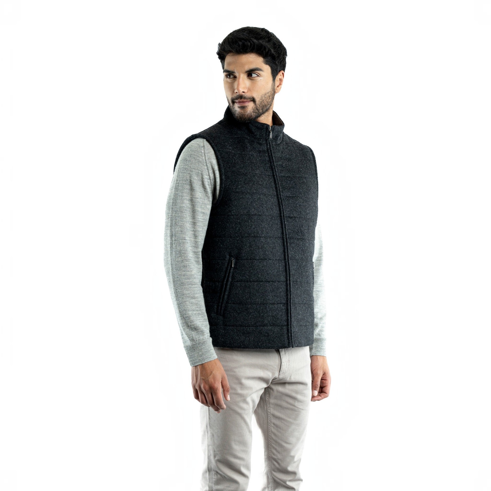 Men’s charcoal quilted baby alpaca vest layered over a grey knit sweater