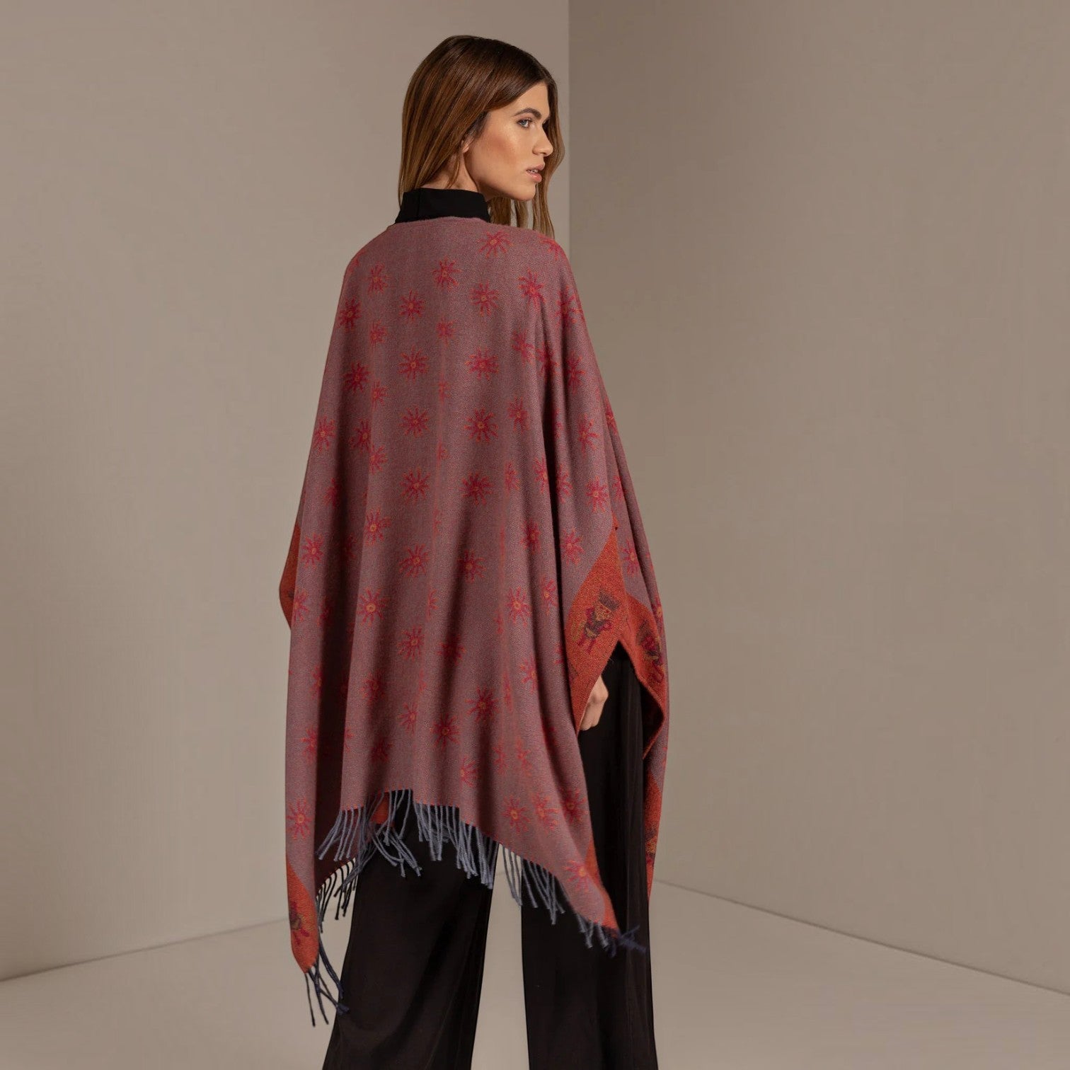 Back view of the Nazca 43 cape reversed to the terracotta side with patterned edging and fringe