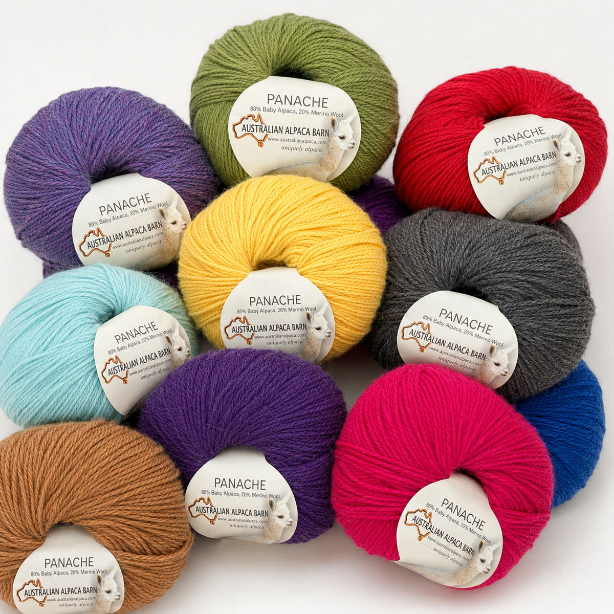 Assorted colorful alpaca yarn balls with Panache labels on a white background