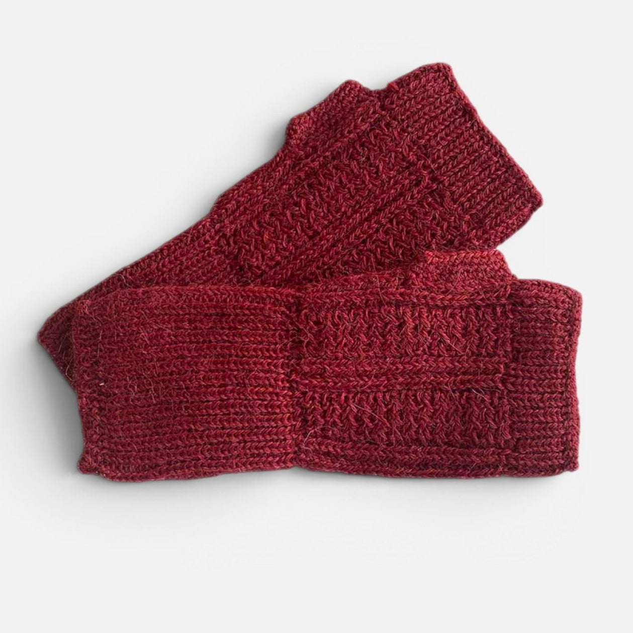 Red baby alpaca wrist warmers with patterned knit panels and thumb-hole design