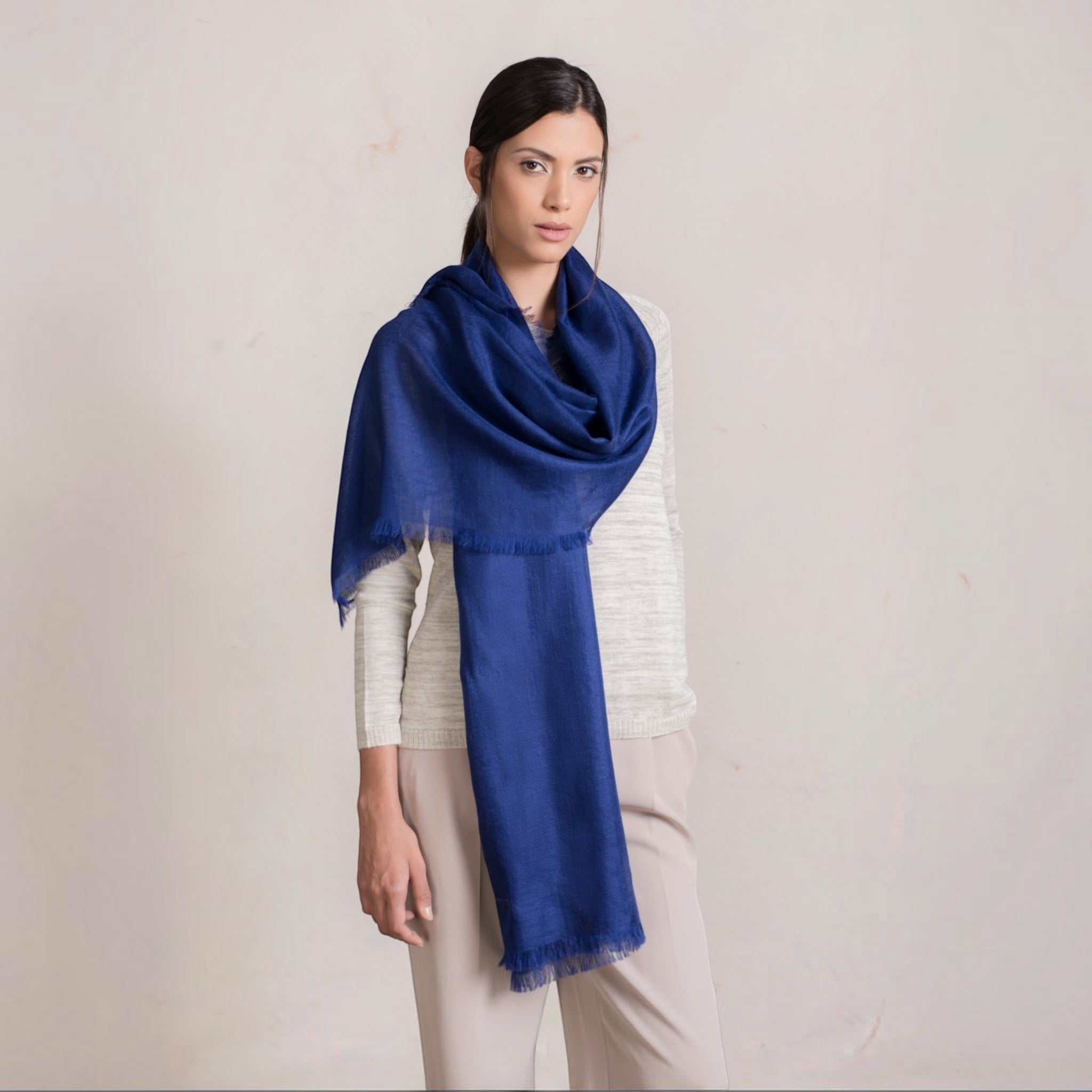 Woman wearing blue alpaca silk shawl, elegant wrap for cool evenings.
