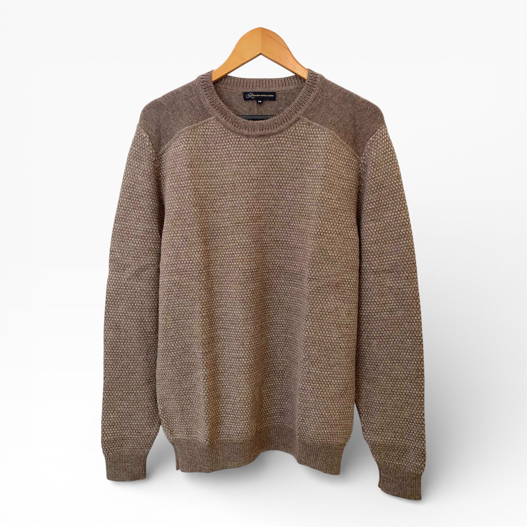Brown sweater on a hanger against a white background