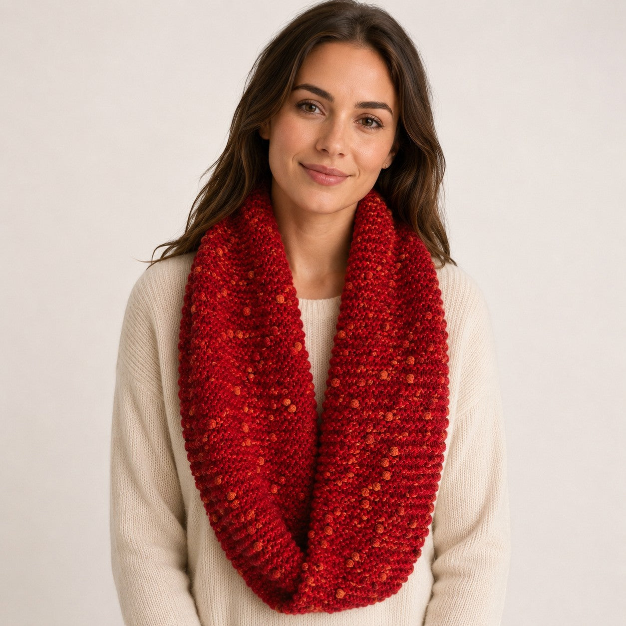 Hand-knitted red Baby Alpaca PomPom snood with warm orange accents
