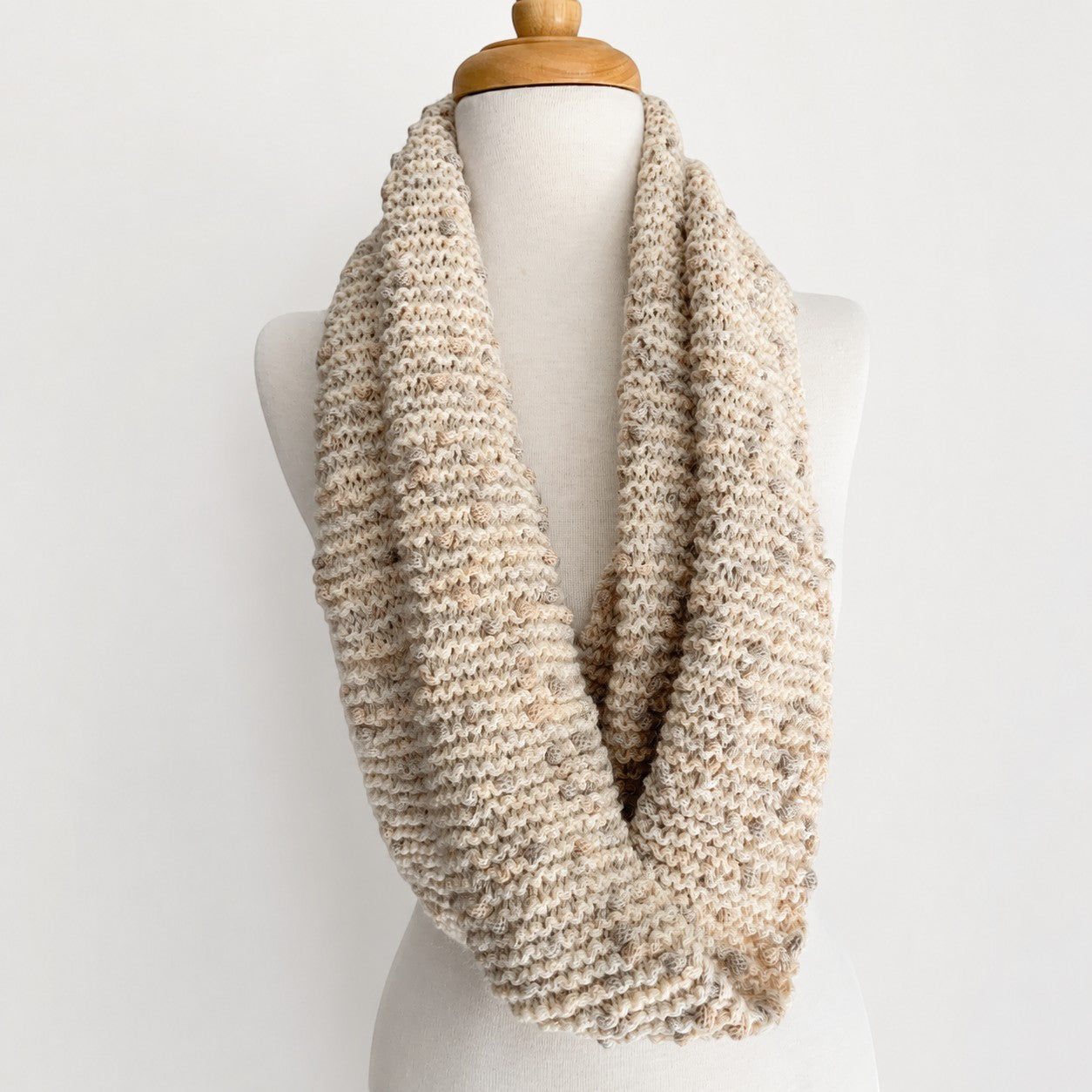 Hand-knitted natural white Baby Alpaca PomPom snood displayed on a mannequin