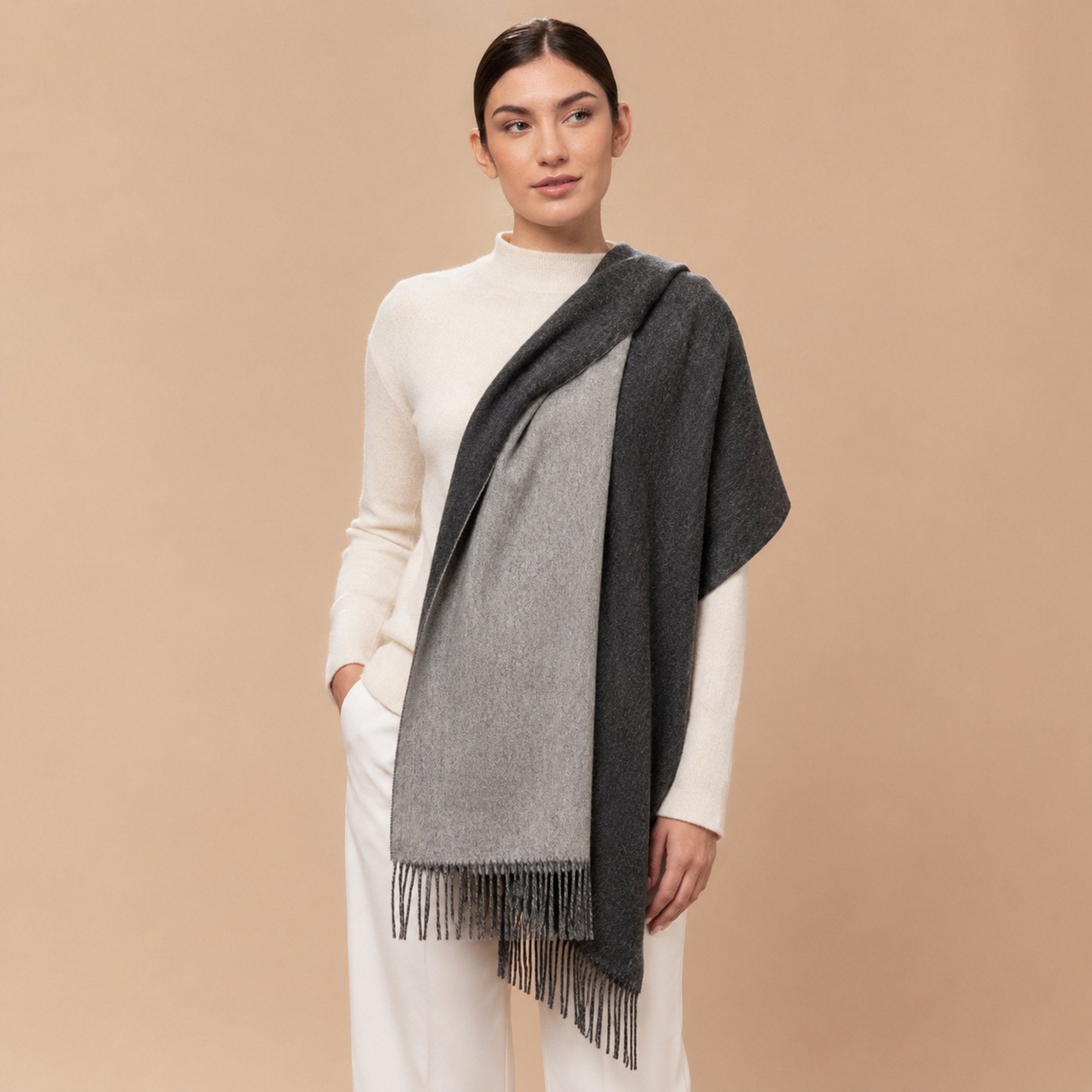 Charcoal and grey reversible Baby Alpaca shawl styled over the shoulders on a female model