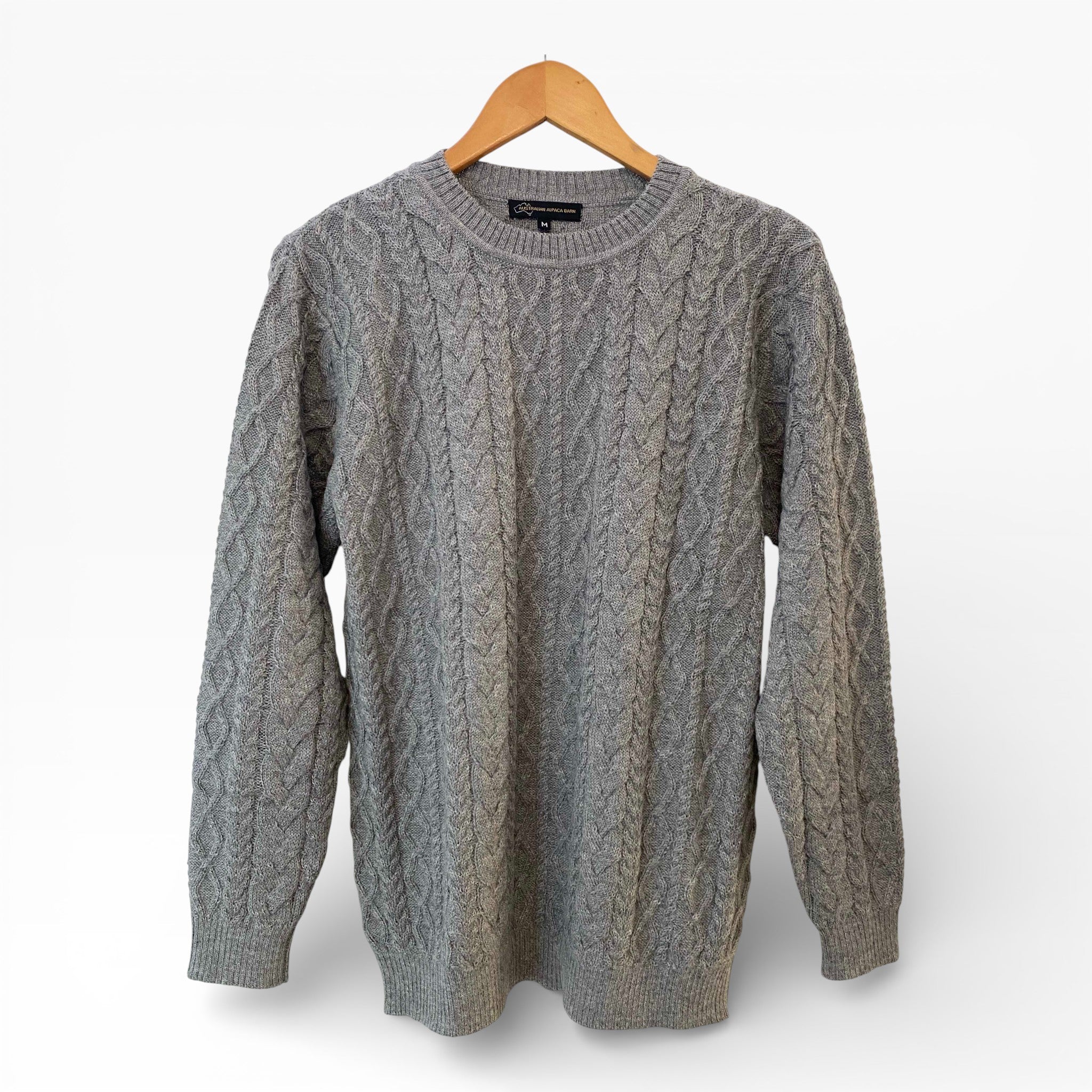 Silver cardigan on a wooden hanger against a white background
