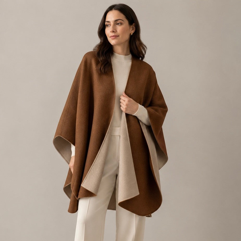 Woman wearing a brown and beige reversible alpaca cape with an open front and flowing drape.