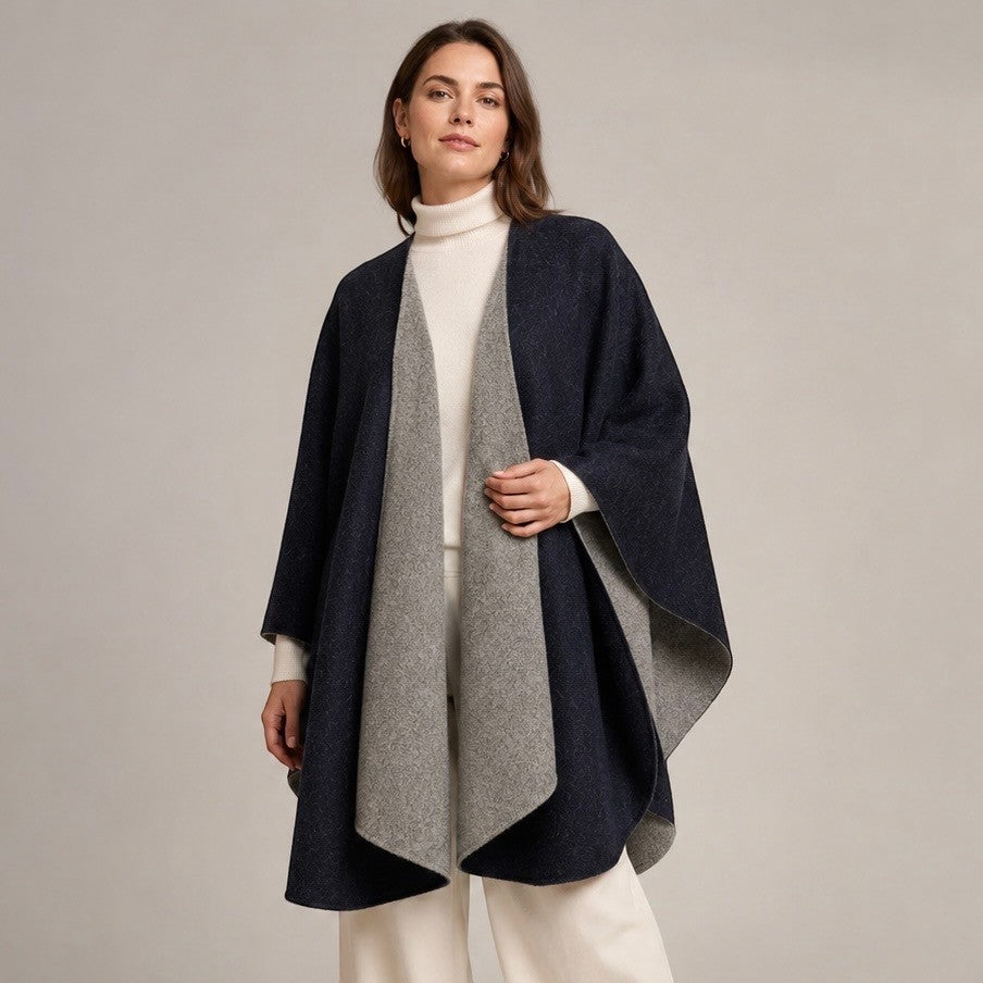 Black reversible cape with a softly draped front, showing the contrasting silver reverse side.