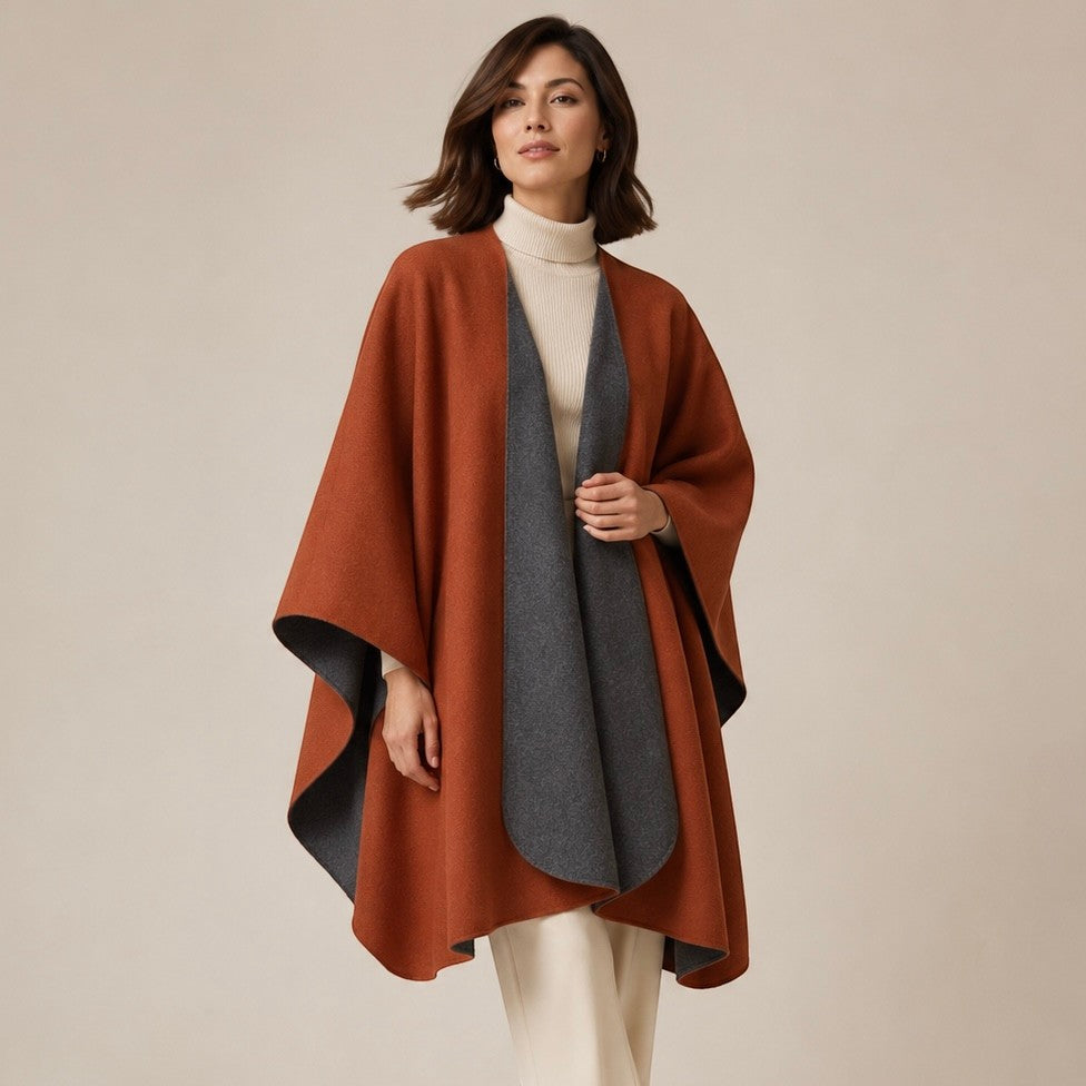 Rust reversible cape with a relaxed drape, showing the contrasting charcoal reverse side.