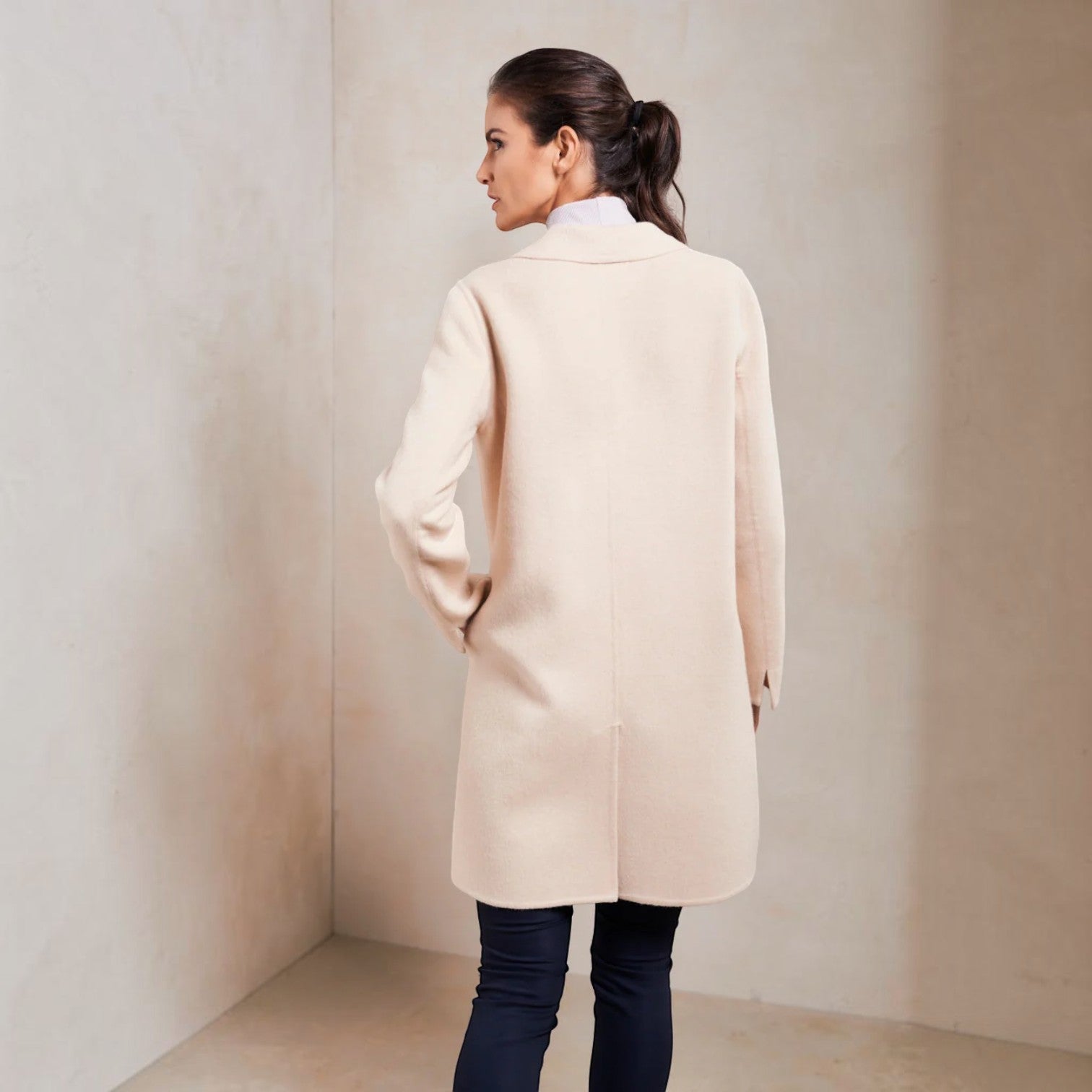 Back view of the Selina cream baby alpaca coat with a straight knee-length silhouette