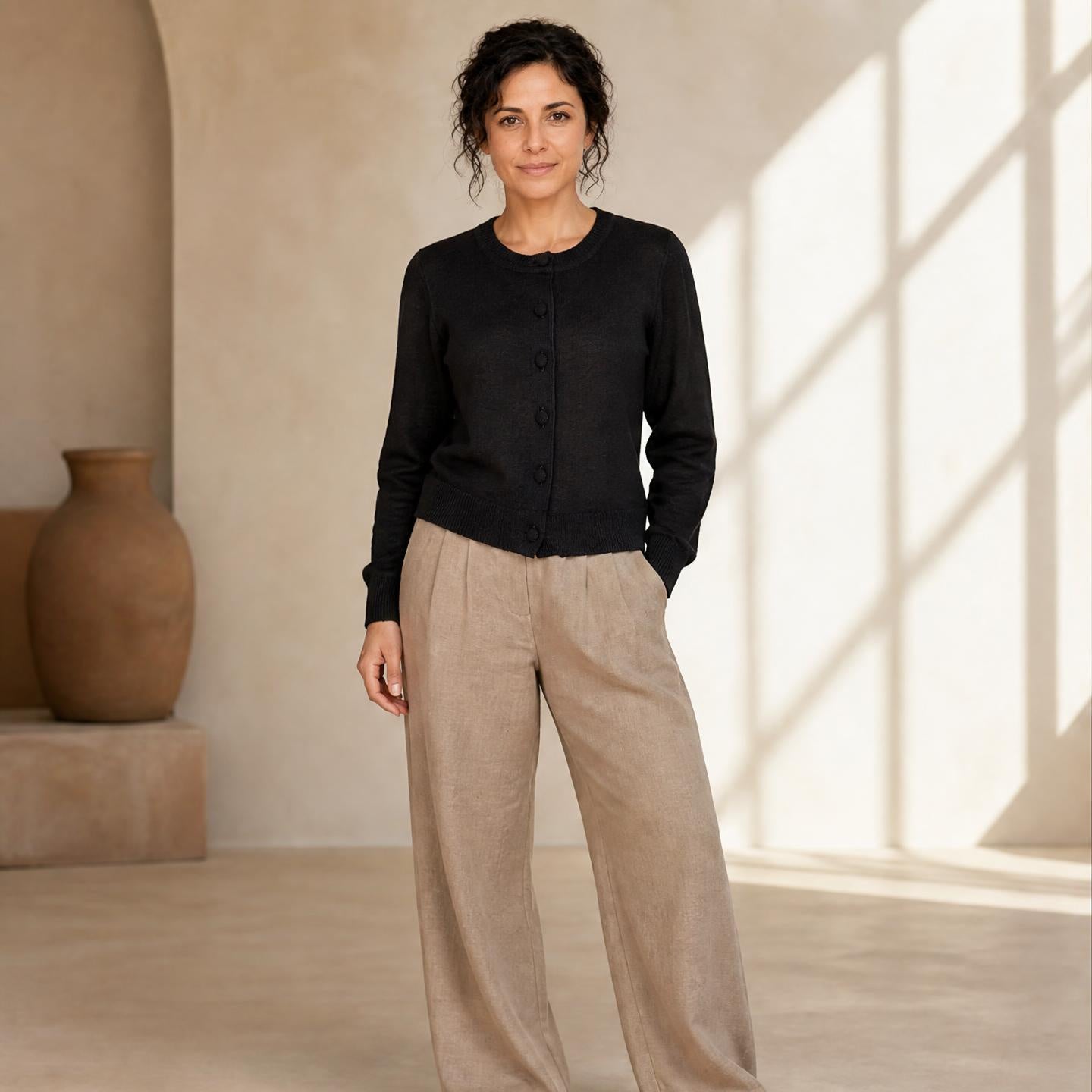 Female model wearing classic black alpaca cardigan with beige trousers