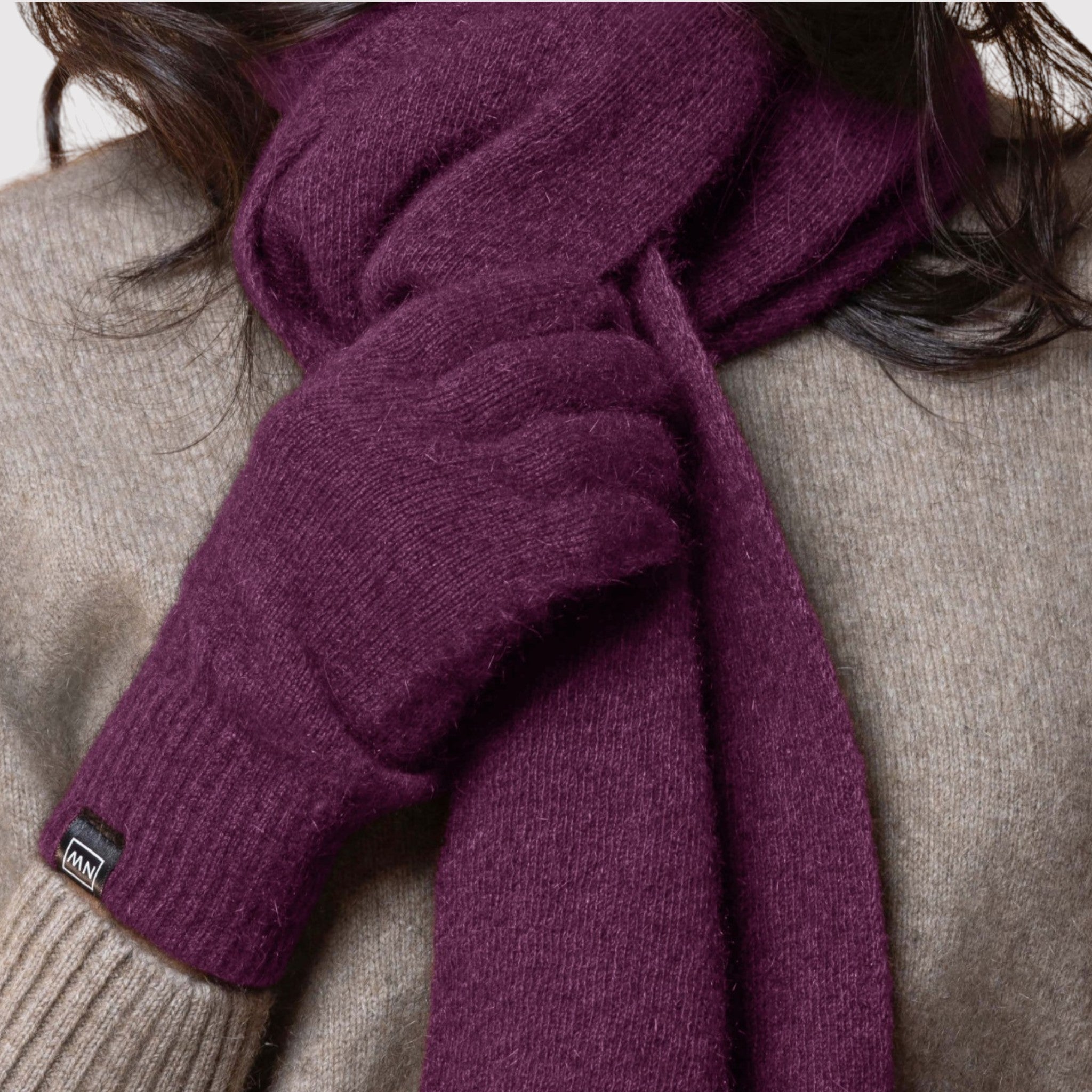 Purple possum scarf being worn by a person with a neutral background