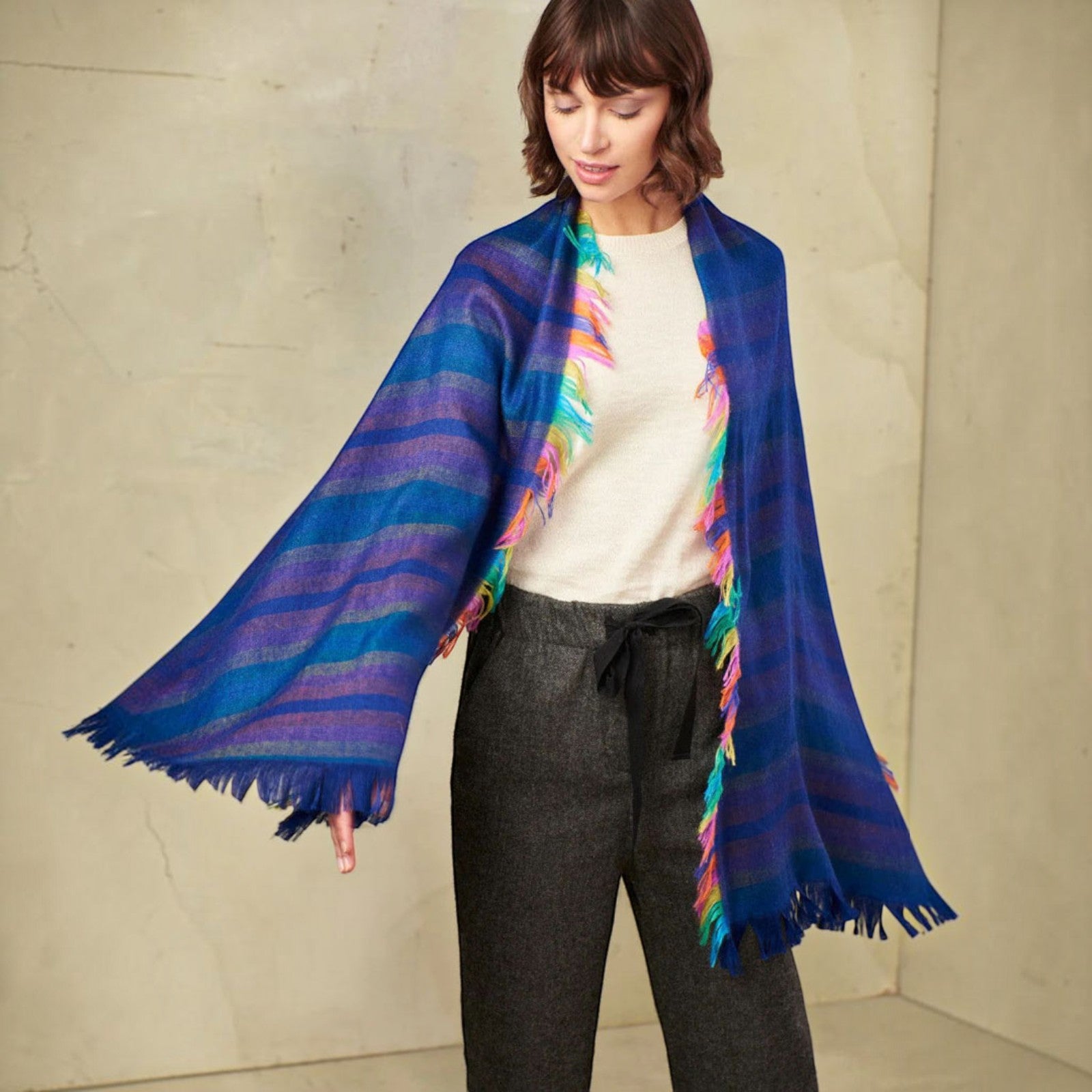 A woman model wearing a vibrant Blue striped Alpaca & Silk shawl.