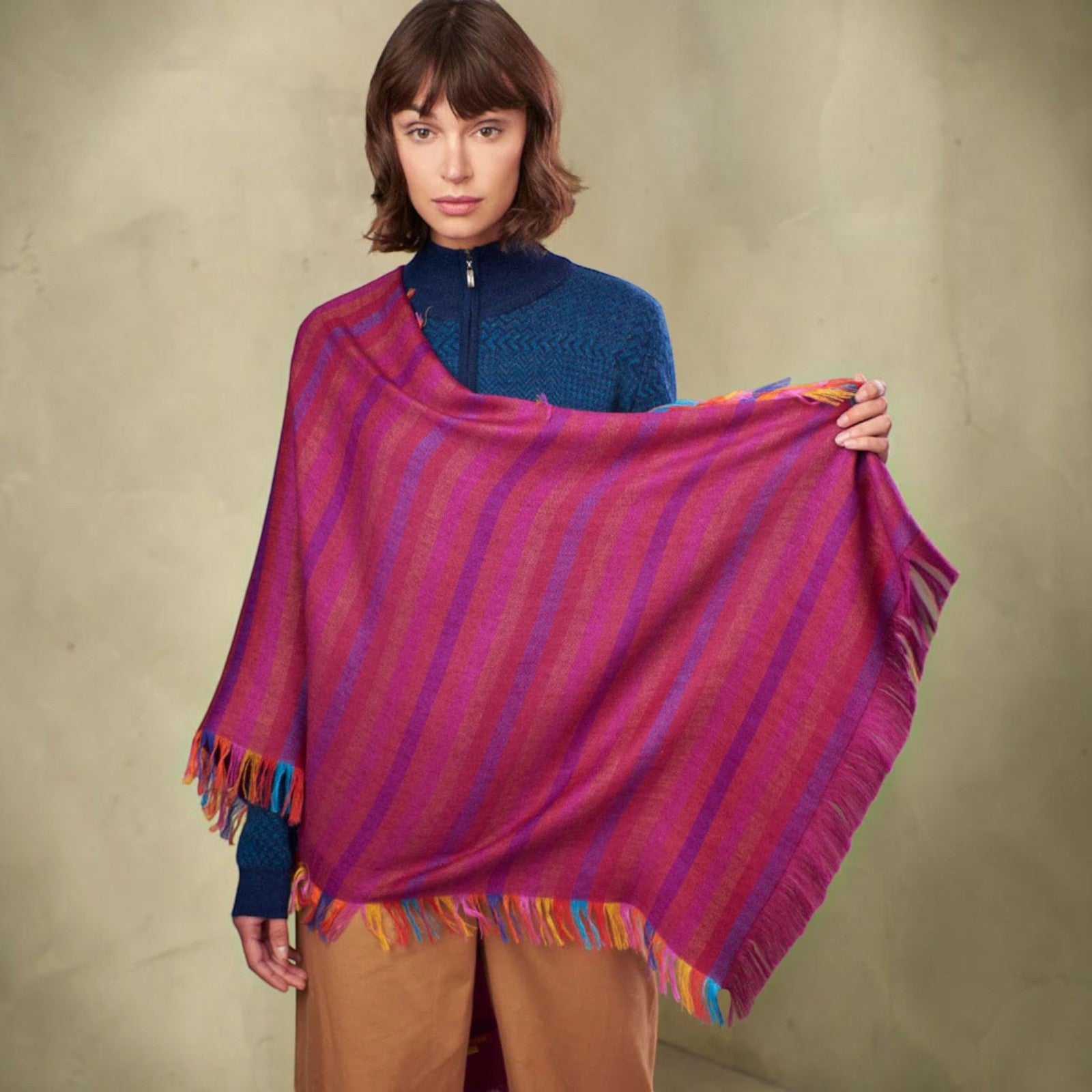 A woman model wearing a vibrant magenta and purple striped Alpaca & Silk shawl.