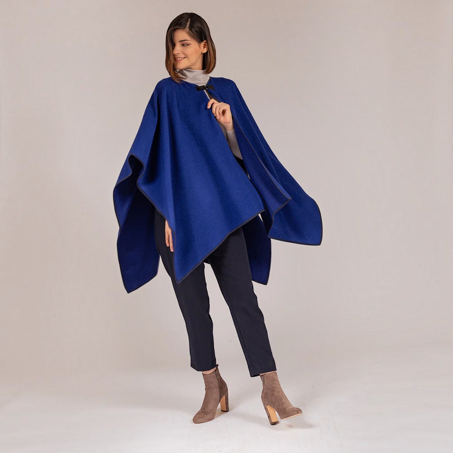 Front view of blue alpaca cape with flowing asymmetric hem