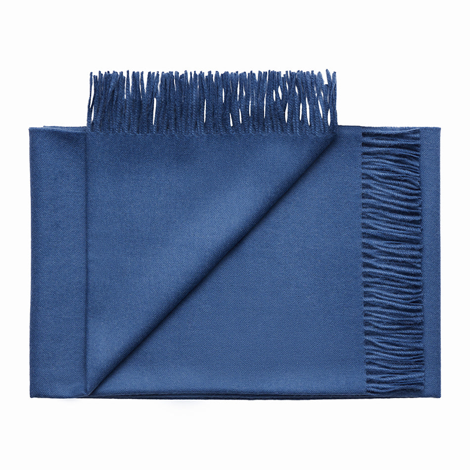 Soft folded 100% baby alpaca blue throw blanket with fringed edges