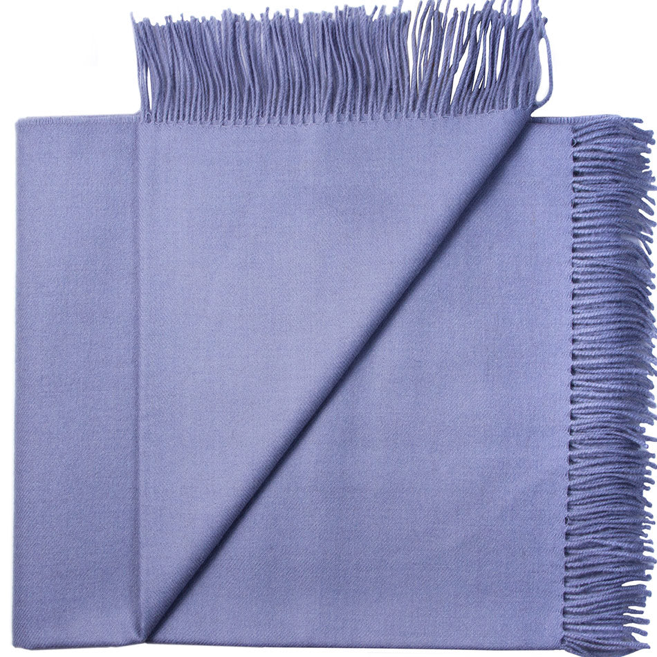Blue throw blanket with fringes folded to show texture and drape