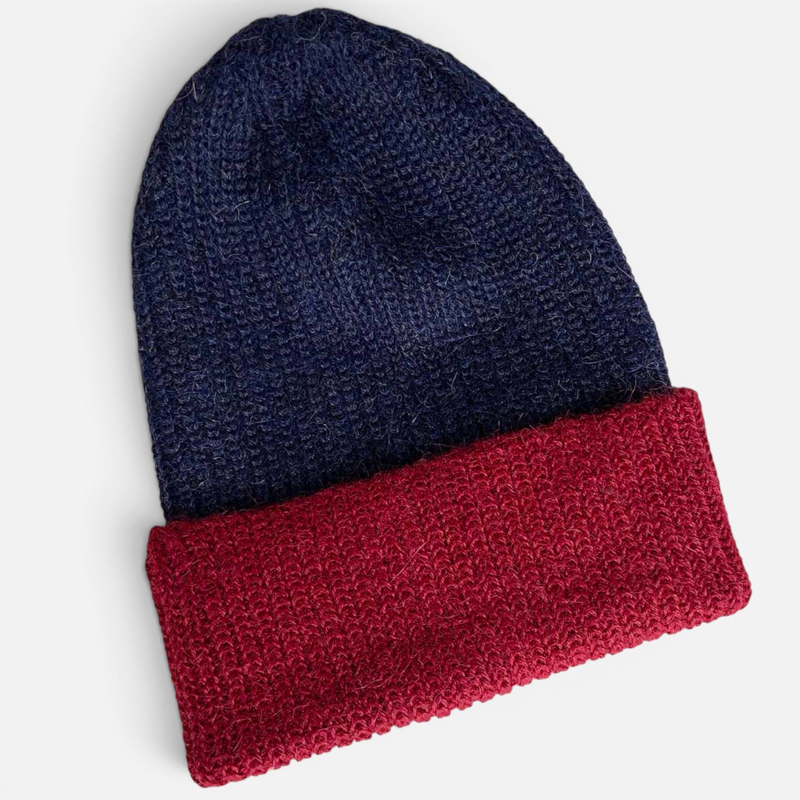 Two-tone ribbed alpaca beanie with a navy crown and contrasting red turned-up brim