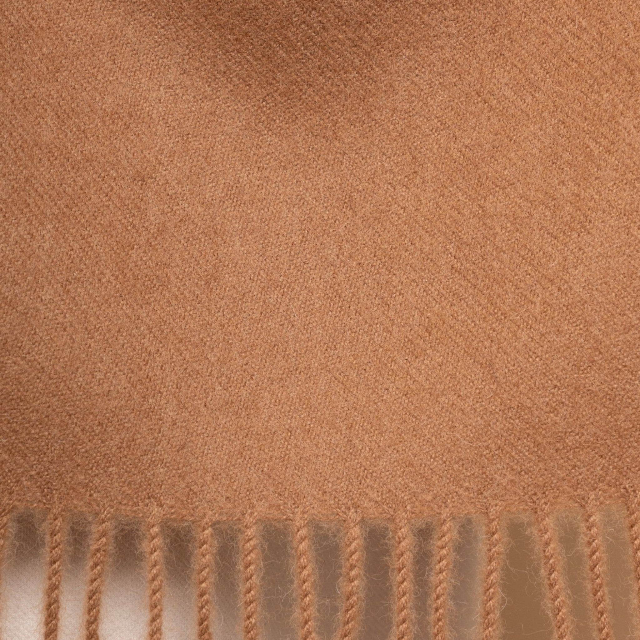 Close up Undyed camel alpaca scarf styled as a warm wrap with elegant fringed finish