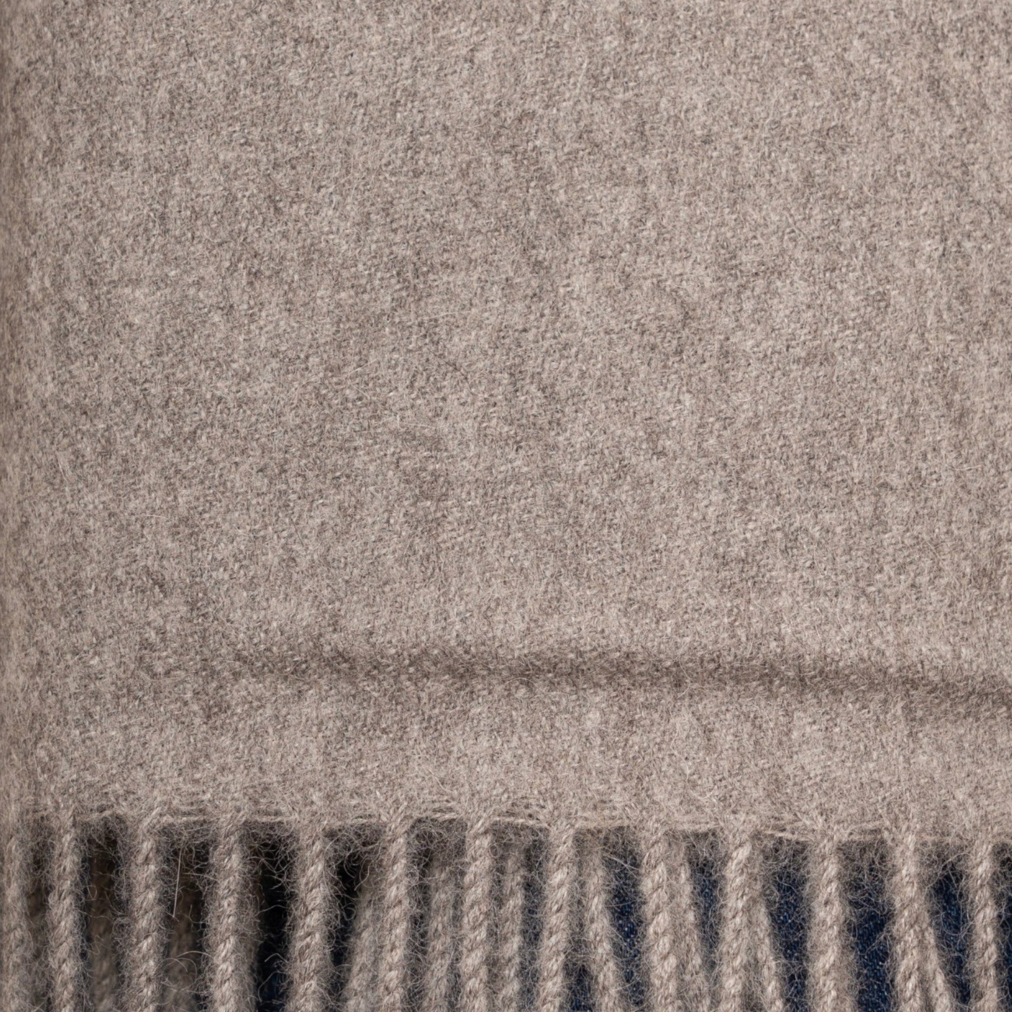 Close up Undyed mid grey alpaca scarf styled for everyday wear with classic fringed edges
