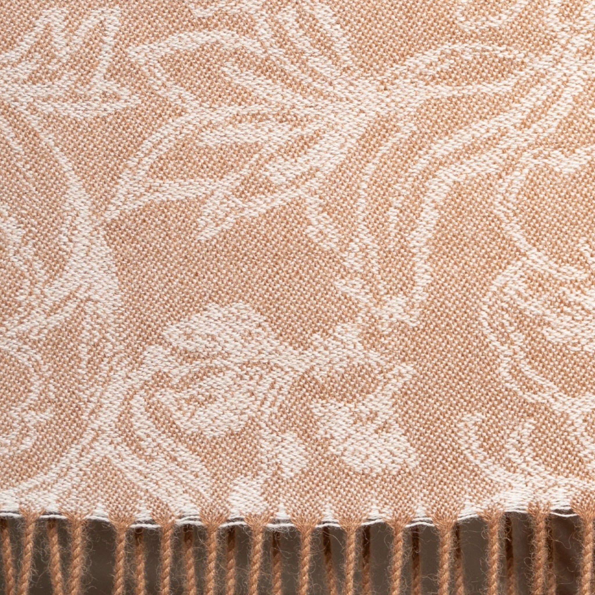 Close up of Undyed beige Baby Alpaca scarf styled as a wrap with delicate floral jacquard detail