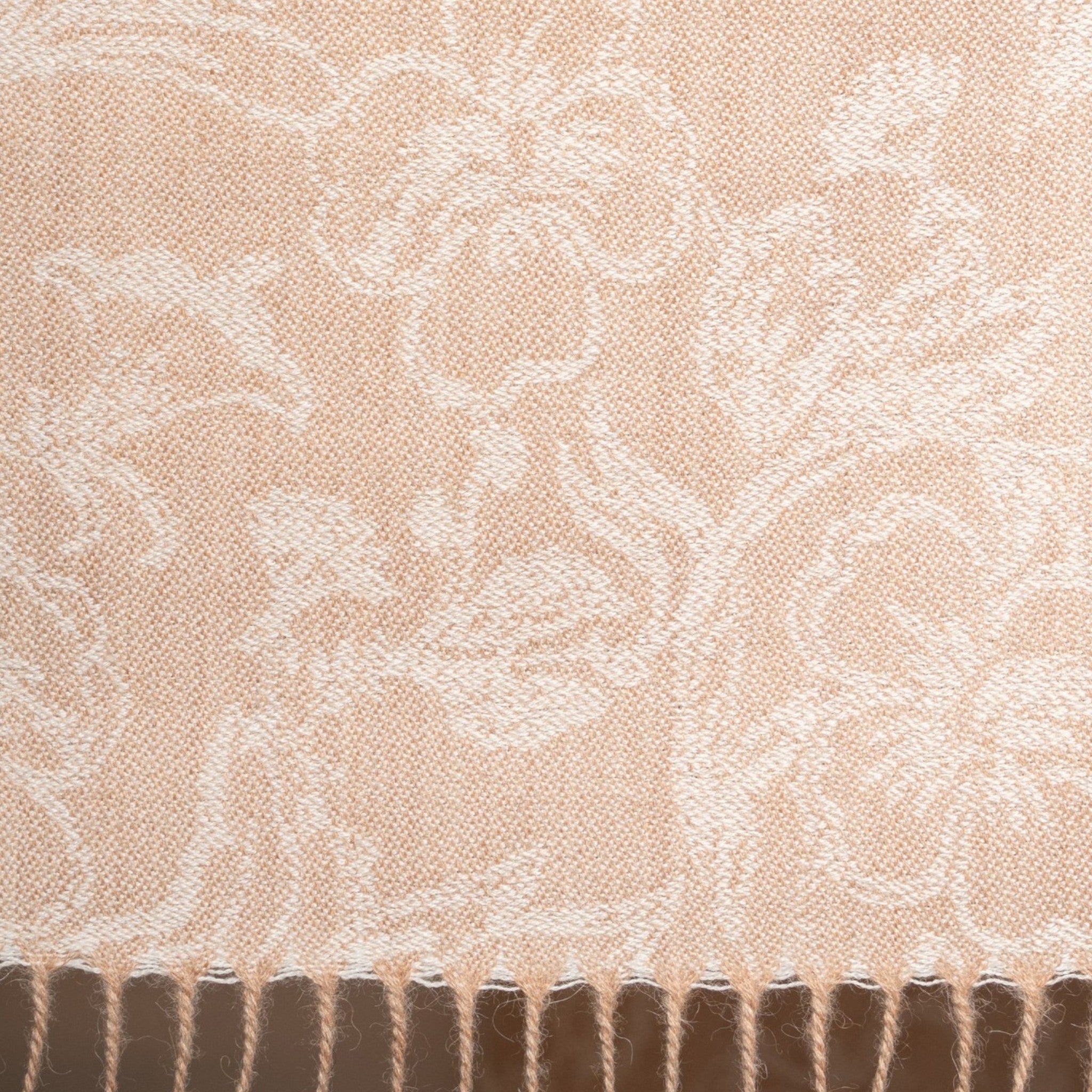 Close up of 100% Baby Alpaca Eco scarf in coral beige with woven floral design and twisted fringe