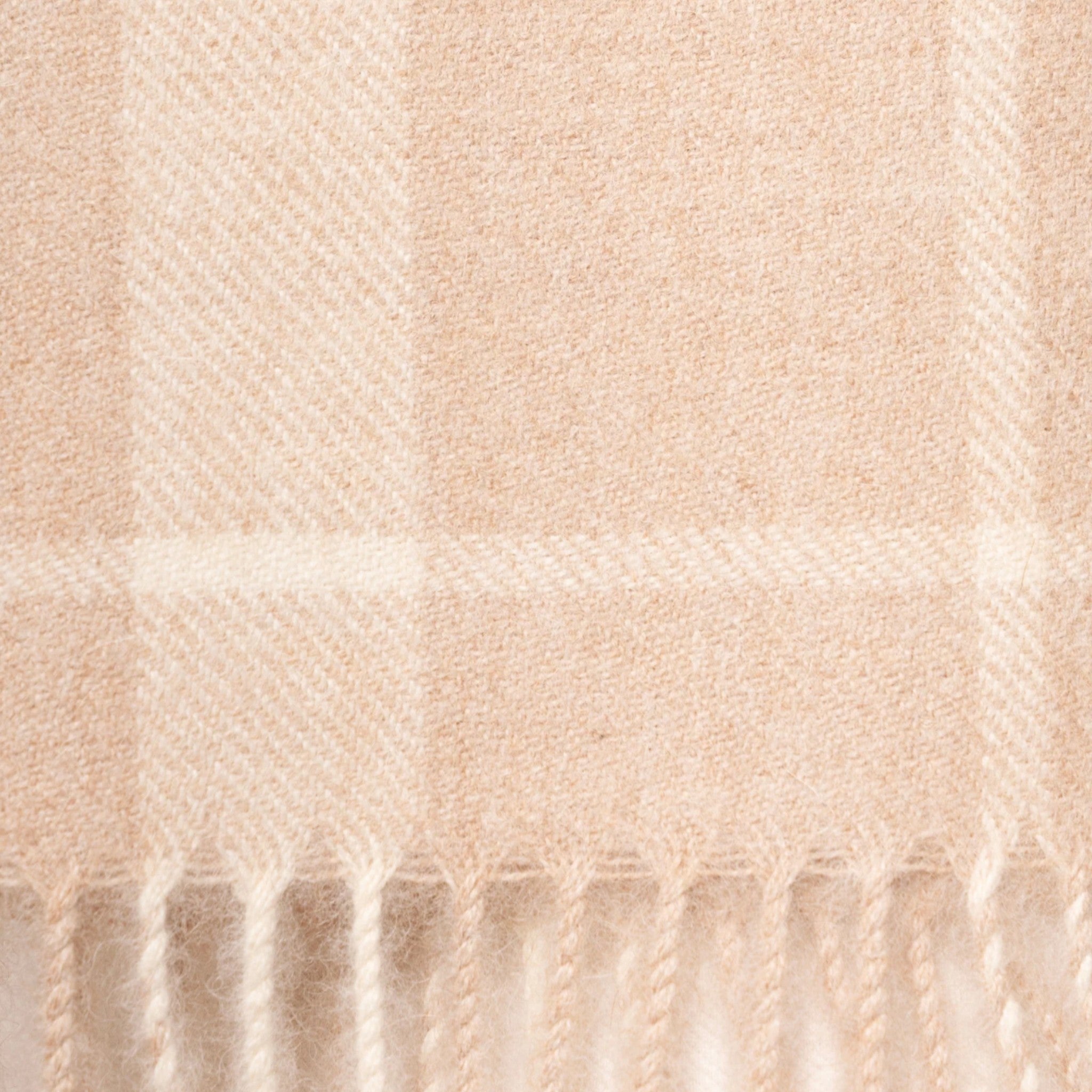 Close up of Undyed white and beige alpaca scarf featuring a soft neutral plaid design for timeless winter styling
