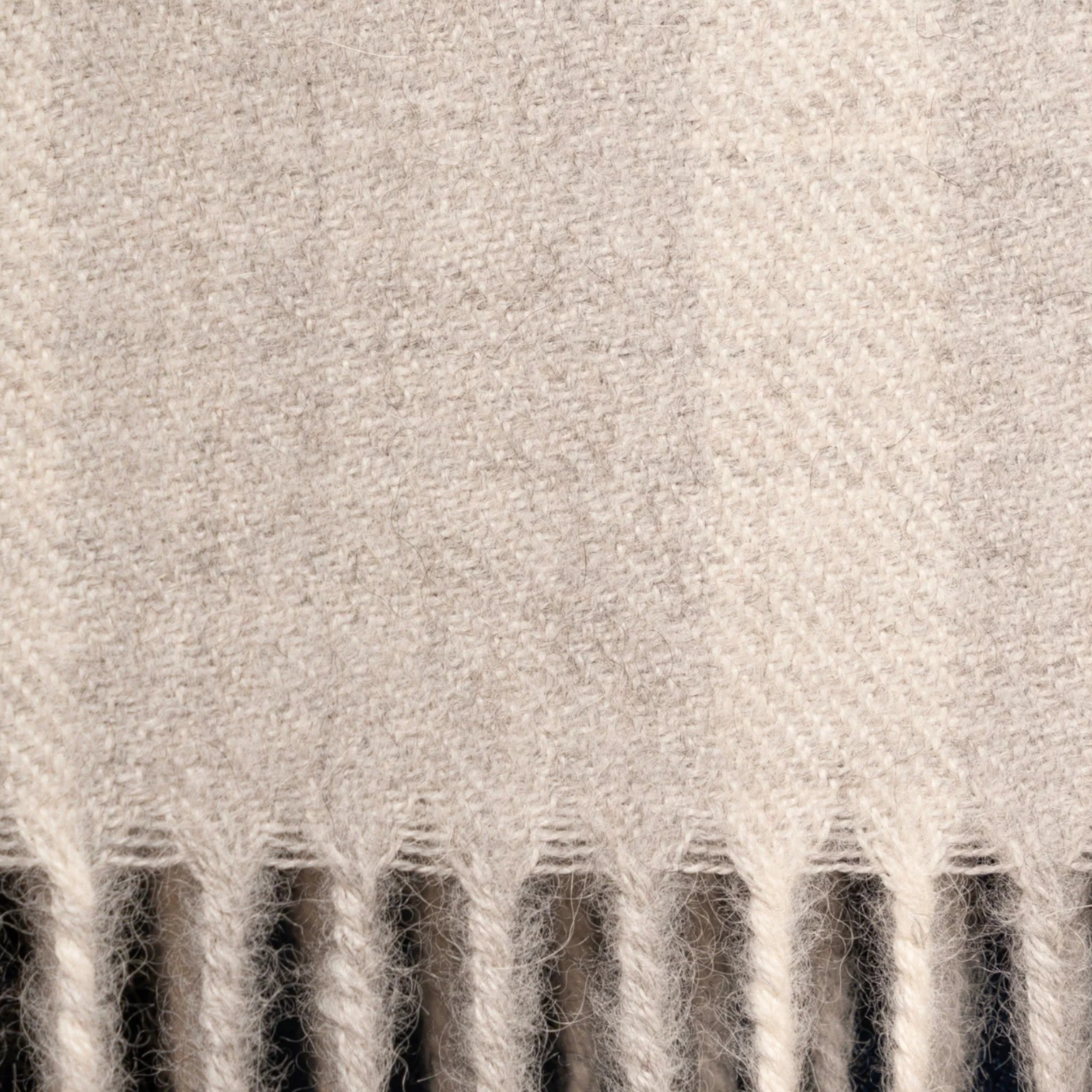 Close up of Undyed Baby Alpaca Eco plaid scarf in white and grey with refined neutral tones and soft drape