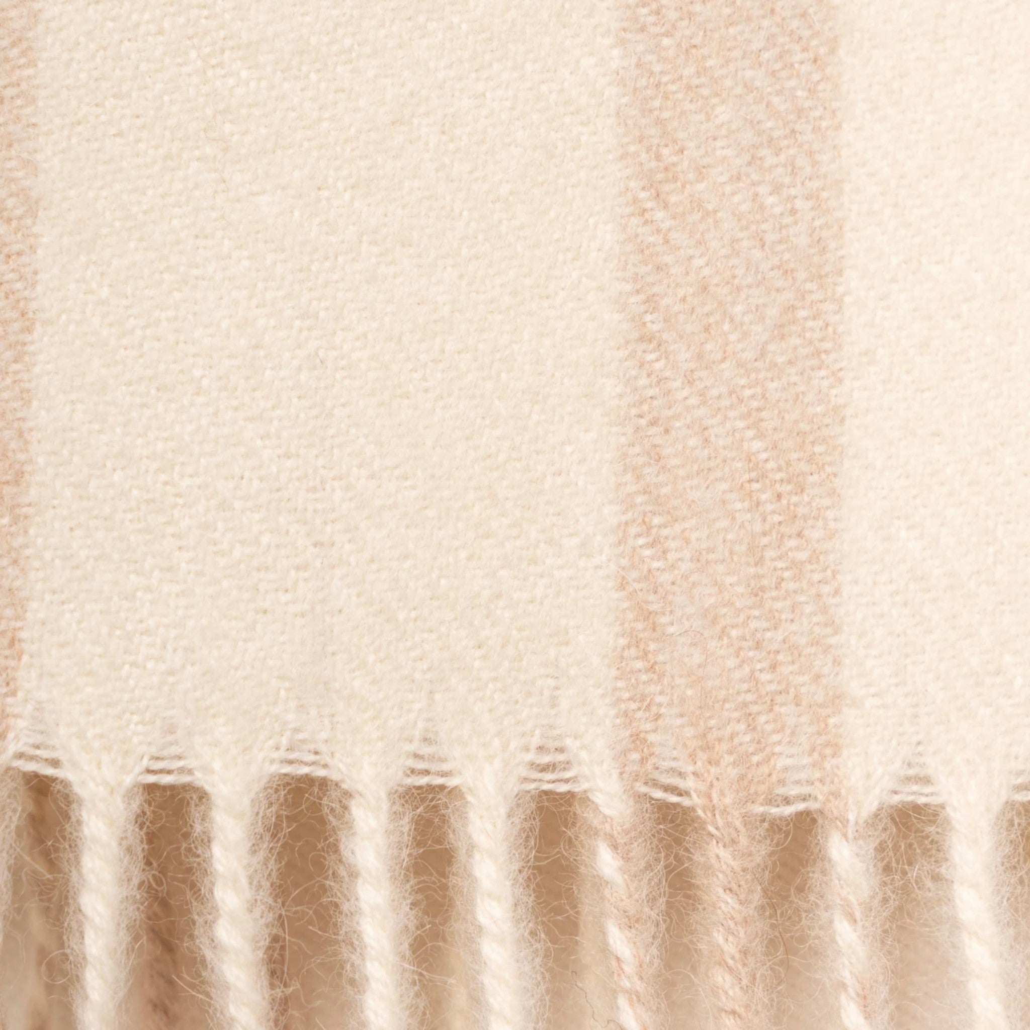 Close Up of Undyed ecru and beige alpaca scarf with classic plaid pattern and softly fringed ends