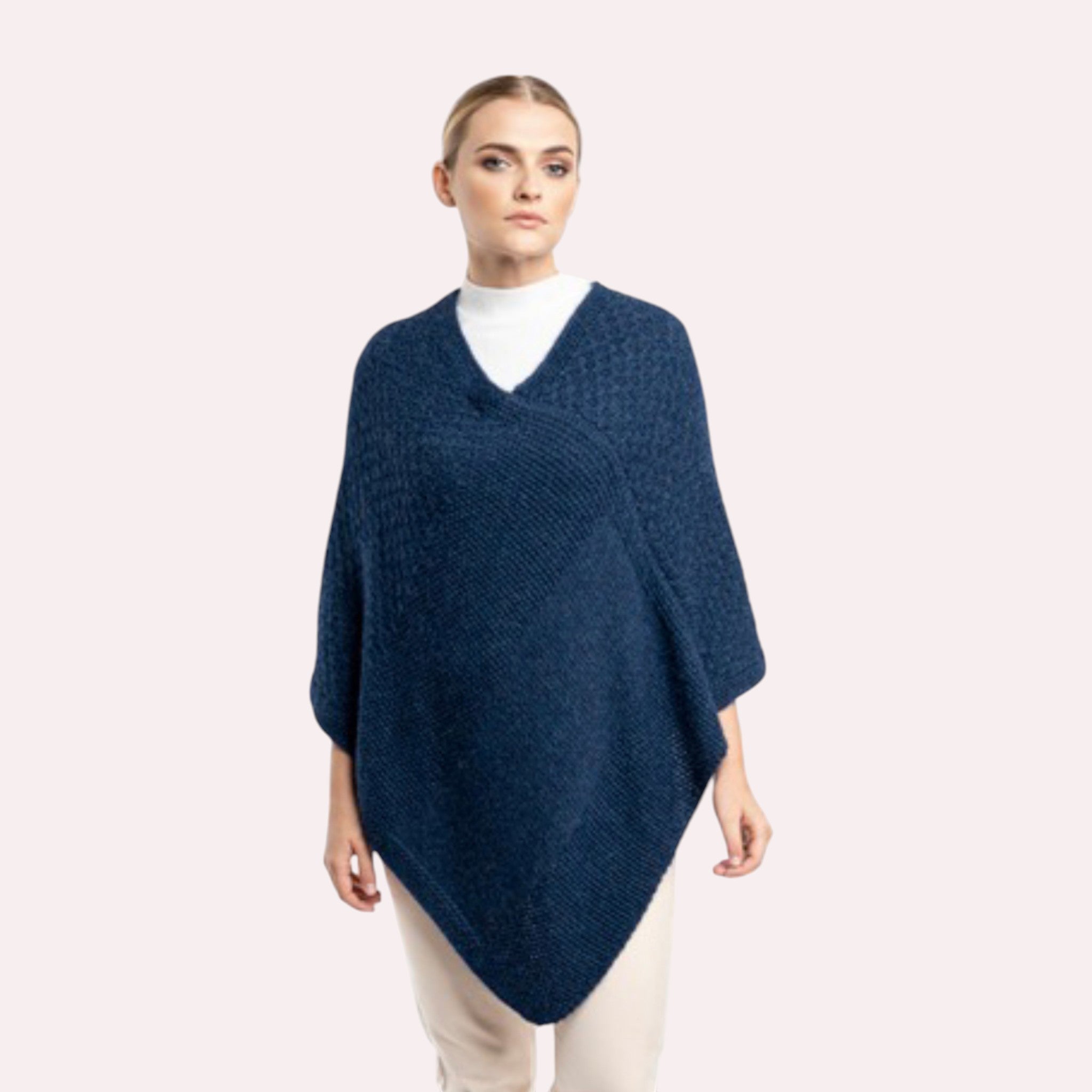 Model in blue alpaca poncho, elegant natural fibre knitwear