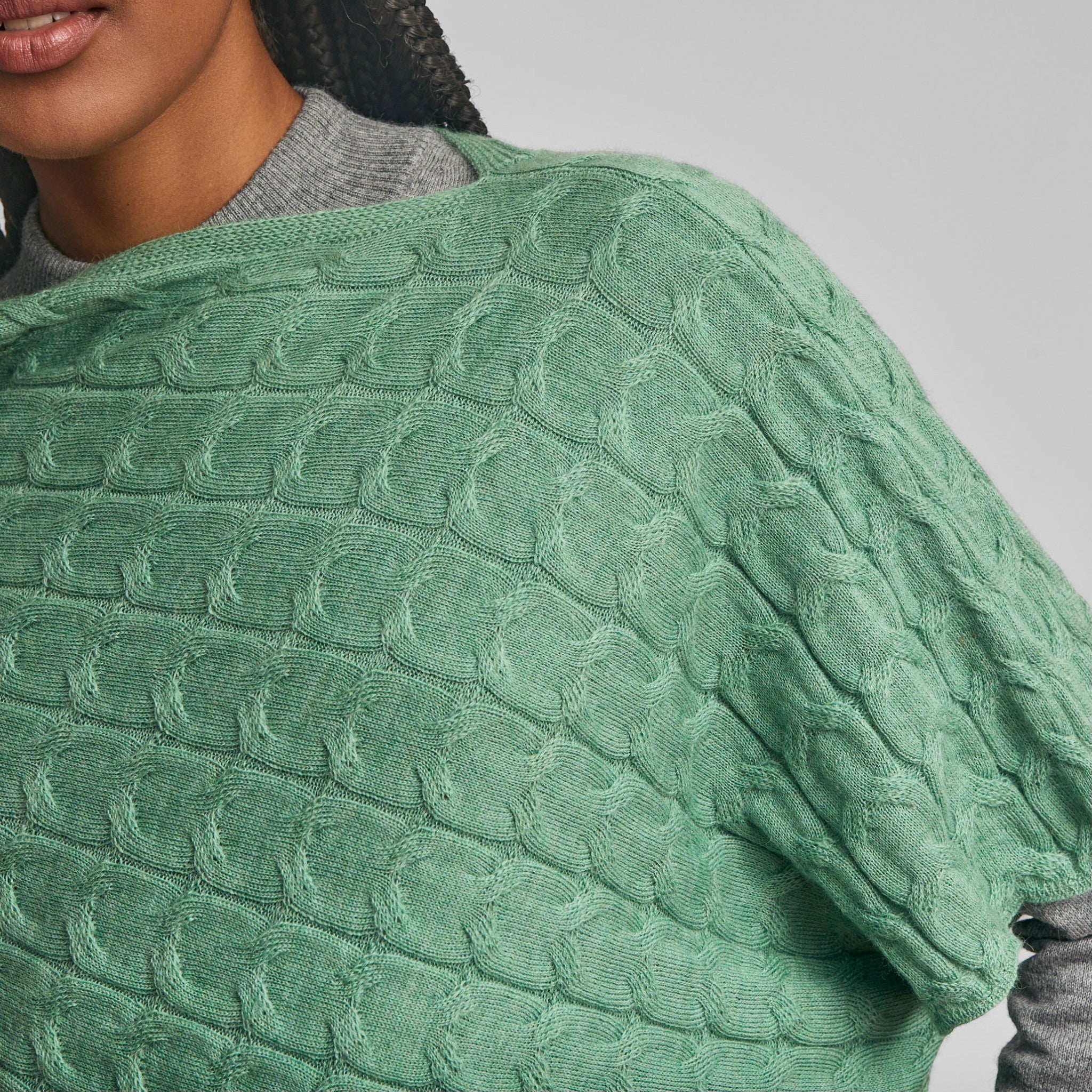 Basil green alpaca poncho with textured knit and asymmetric hem