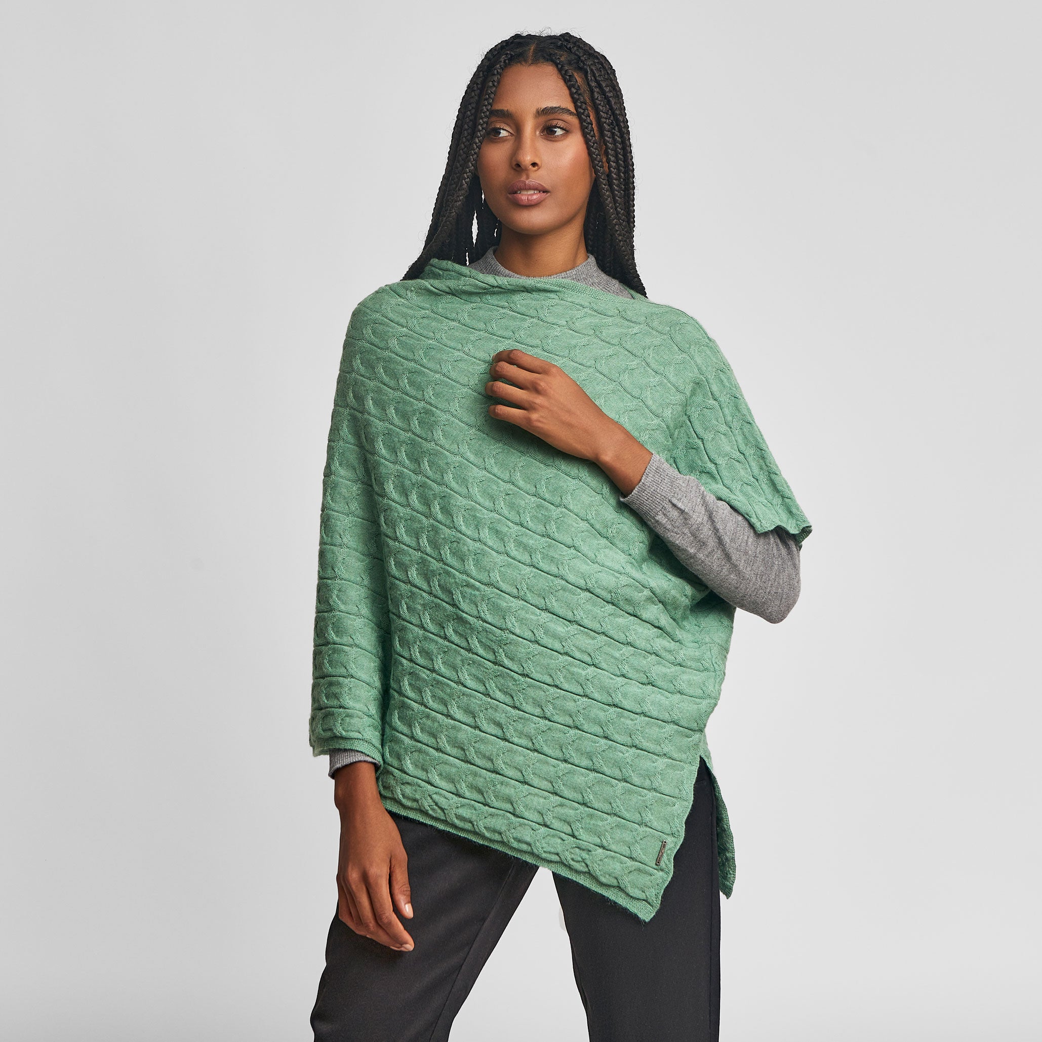 Woman wearing the Willow Baby Alpaca Poncho in basil green