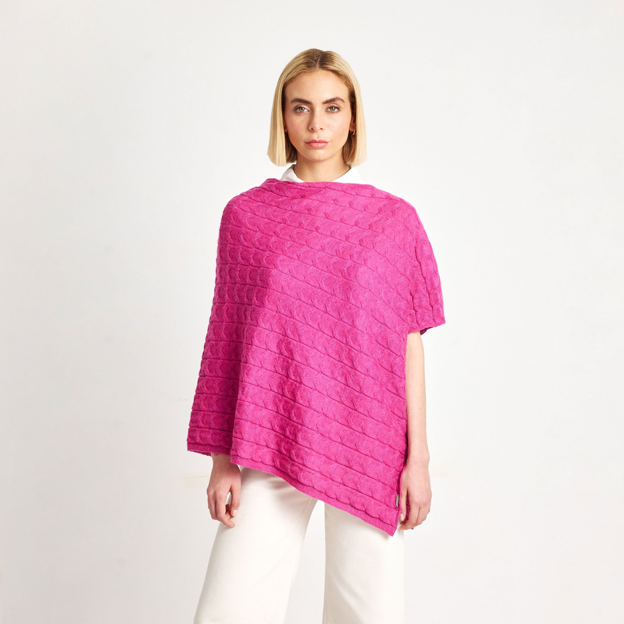 Woman wearing the Willow Baby Alpaca Poncho in bright ceremony pink