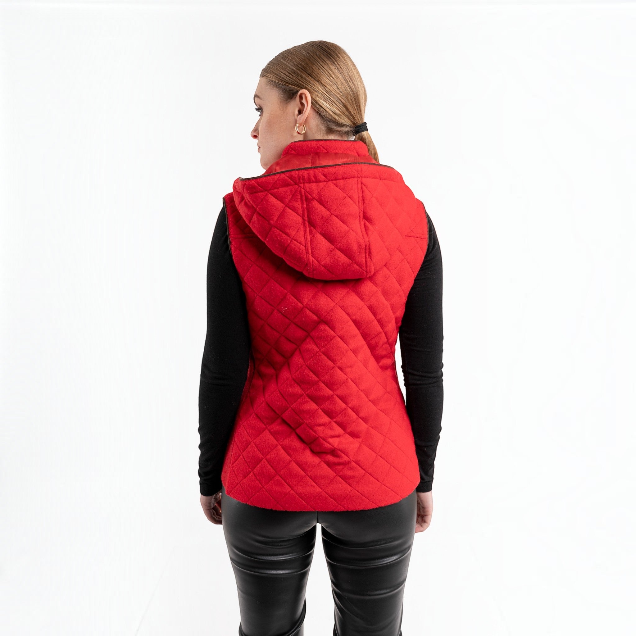 Close-up of red hooded alpaca vest showing the quilted texture and stand collar