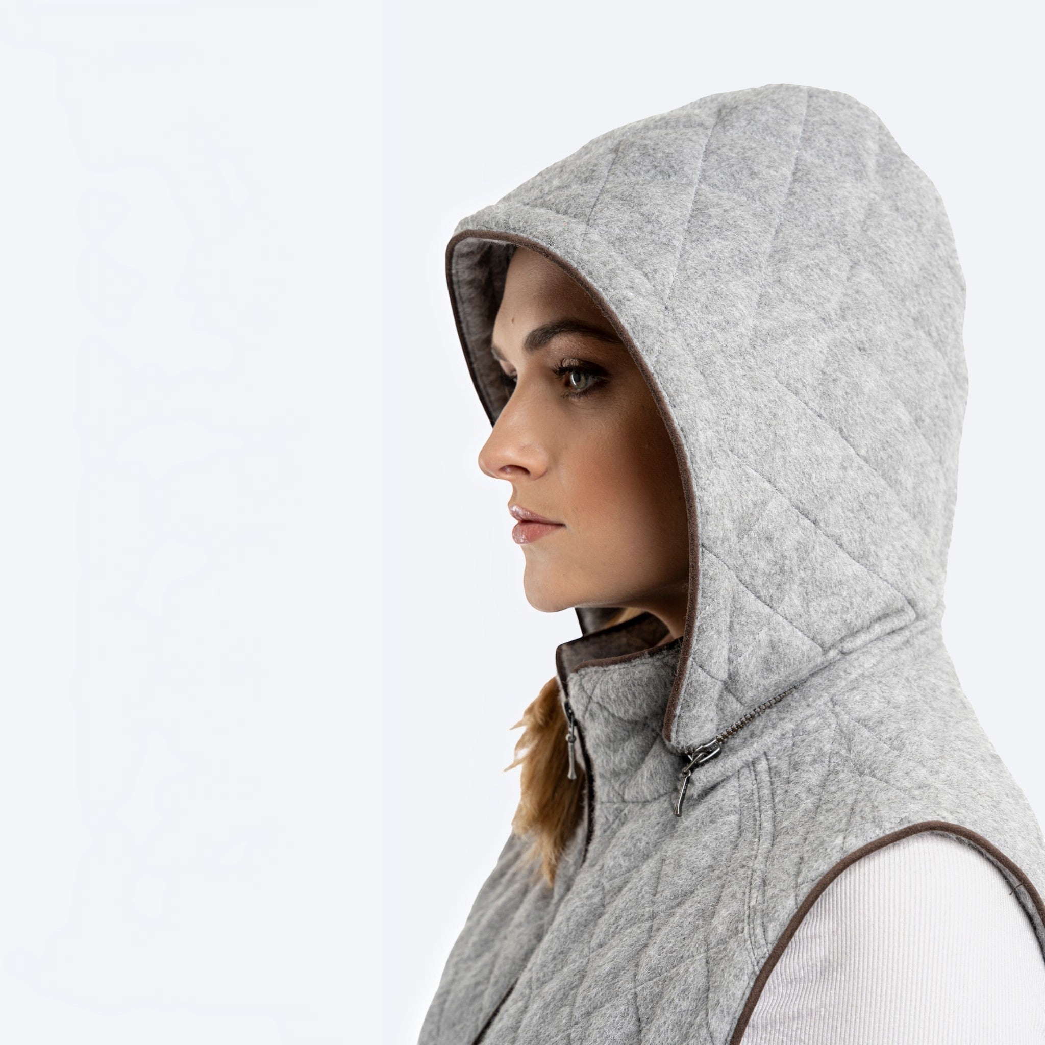 Close-up of silver quilted alpaca vest with the hood raised and contrast trim