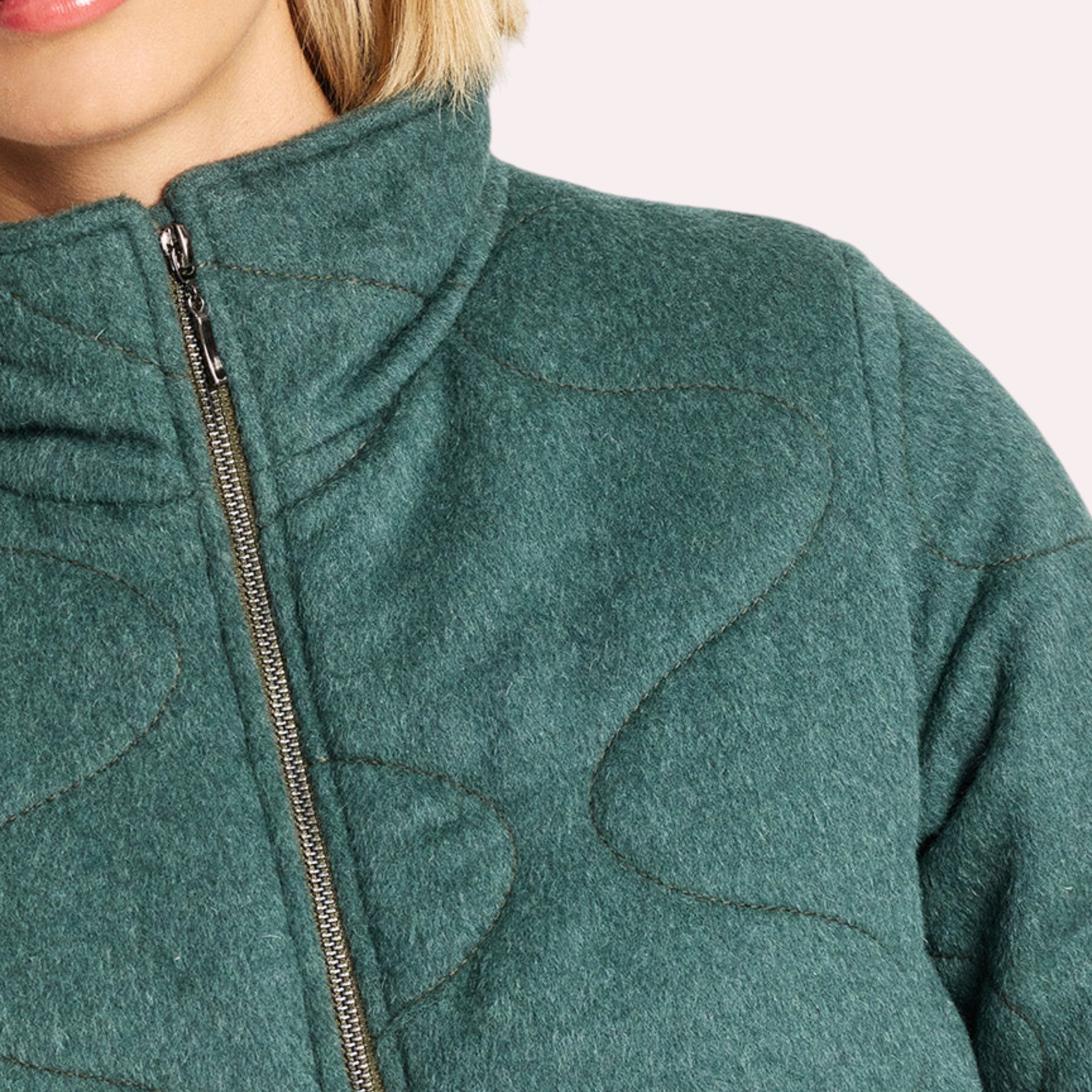 Quilted detail on padded alpaca coat with soft natural fibre texture.