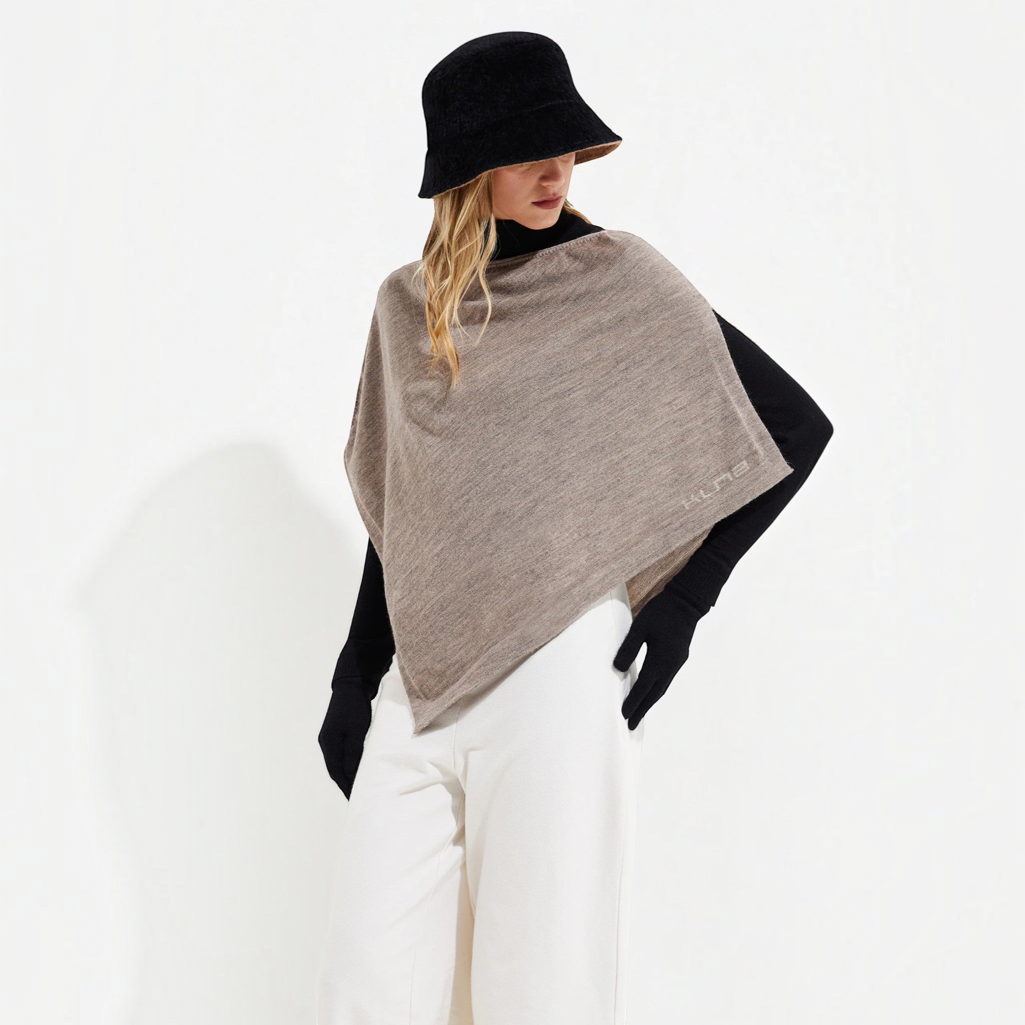 Women’s Yura Baby Alpaca and silk poncho in soft taupe, styled with white trousers