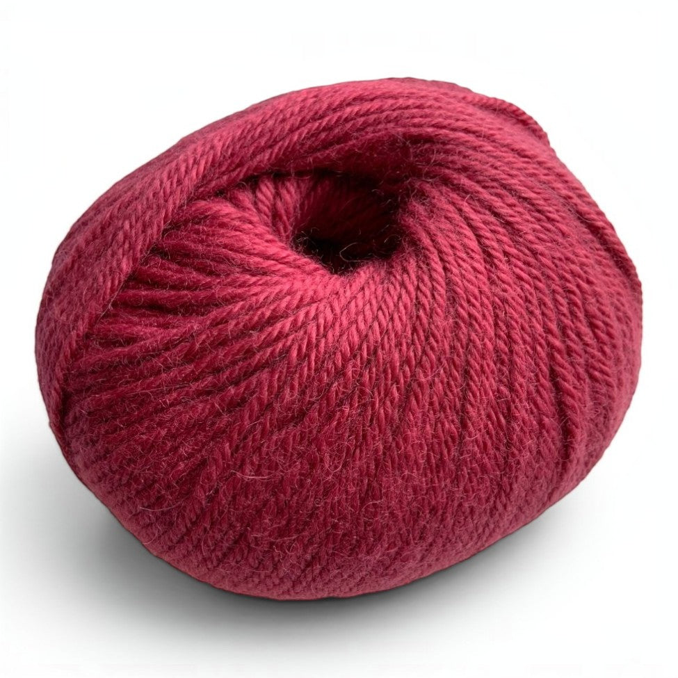 Ball of 100% baby alpaca sport weight yarn in rich claret red.