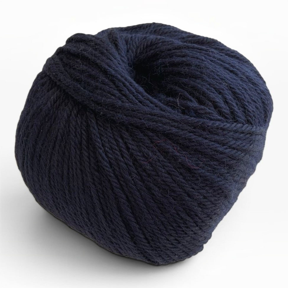 Ball of 100% baby alpaca sport weight yarn in deep navy blue.