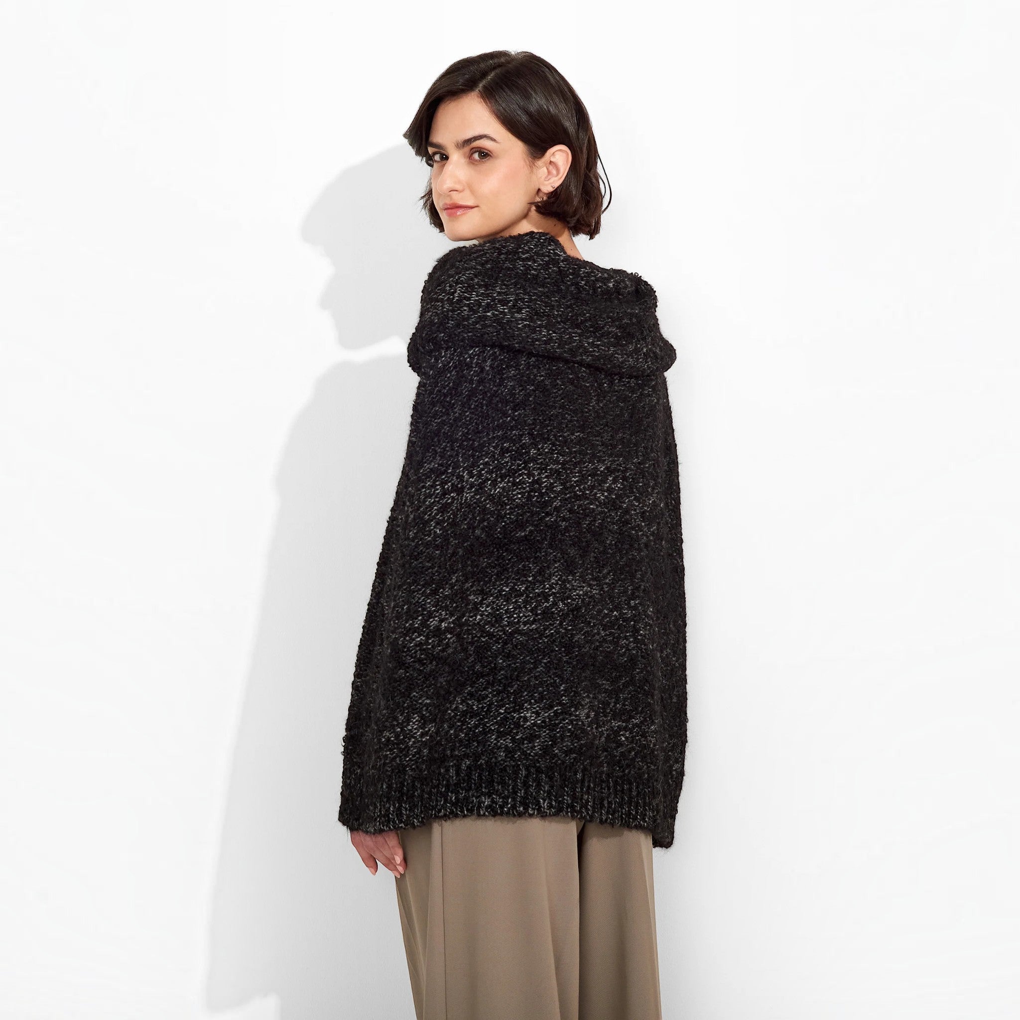 Back view of a woman wearing the Zaira Suri and Baby Alpaca poncho in black caviar