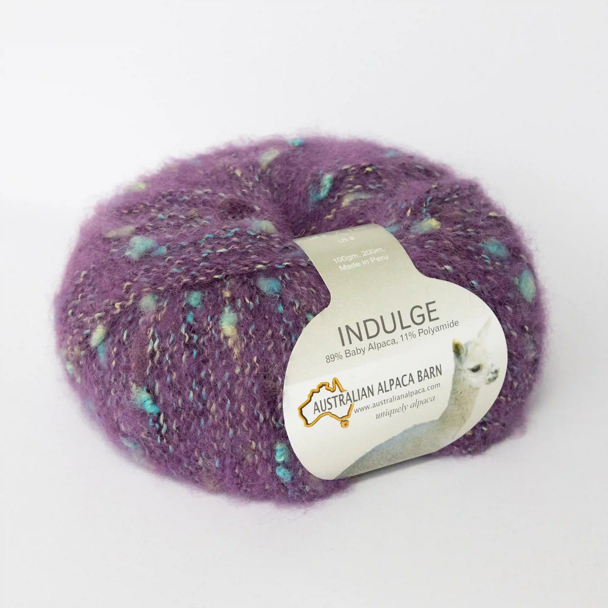 Amethyst Indulge baby alpaca bouclé yarn with its product label visible.