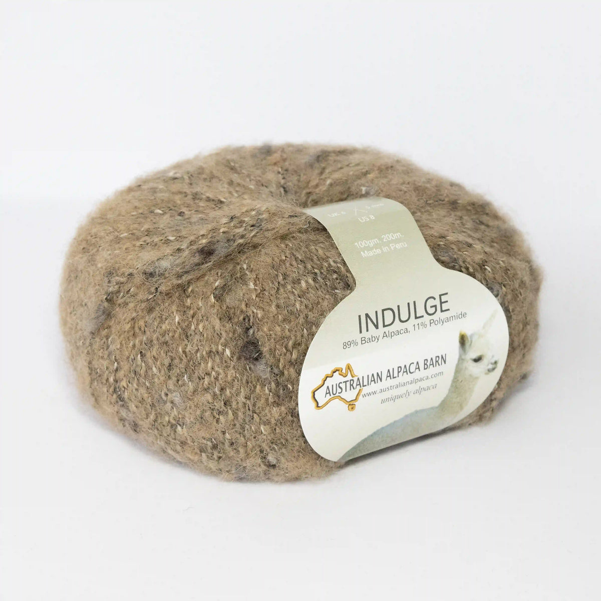 Camel Indulge baby alpaca bouclé yarn with its product label visible.