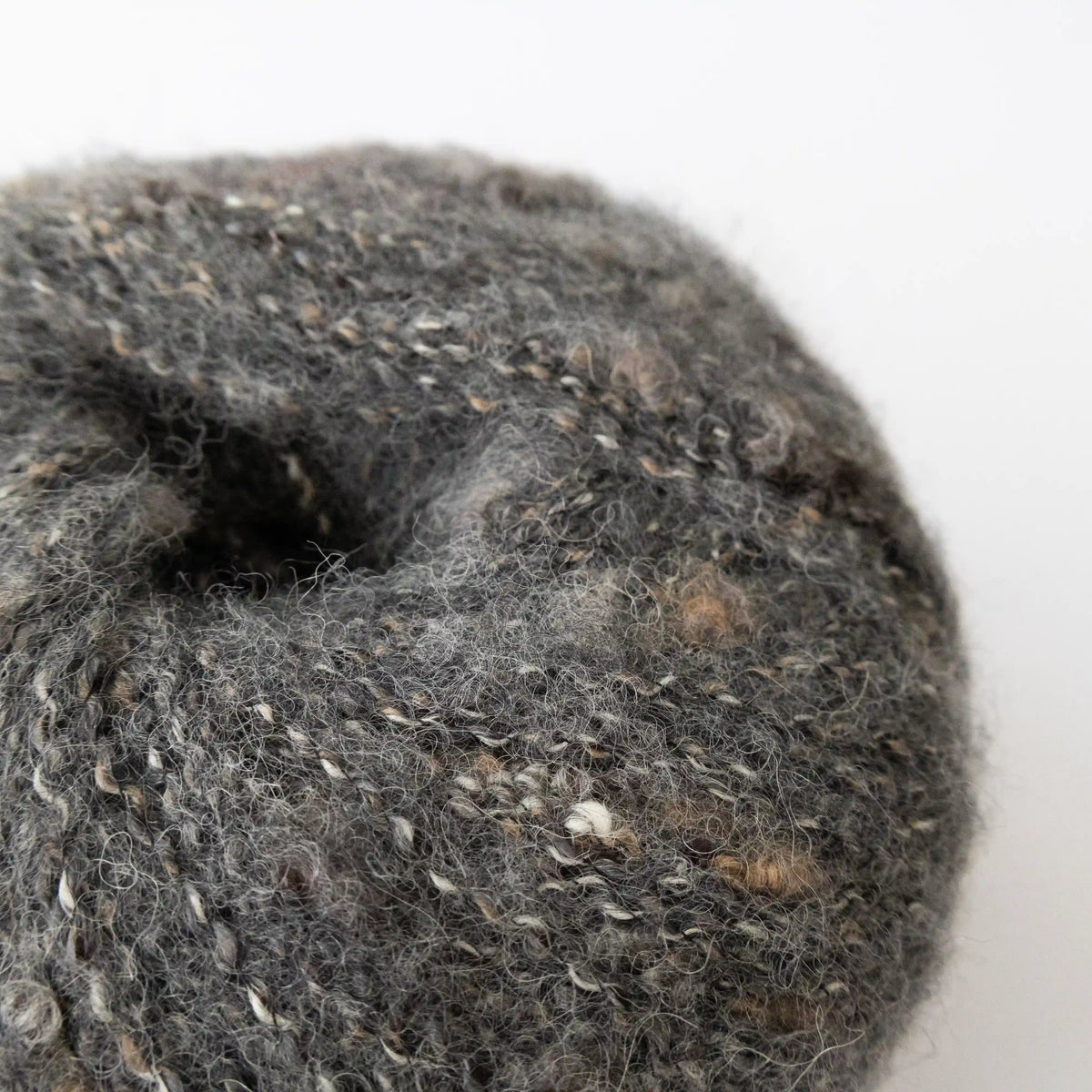 Close-up of Charcoal Indulge baby alpaca bouclé yarn showing its looped texture.