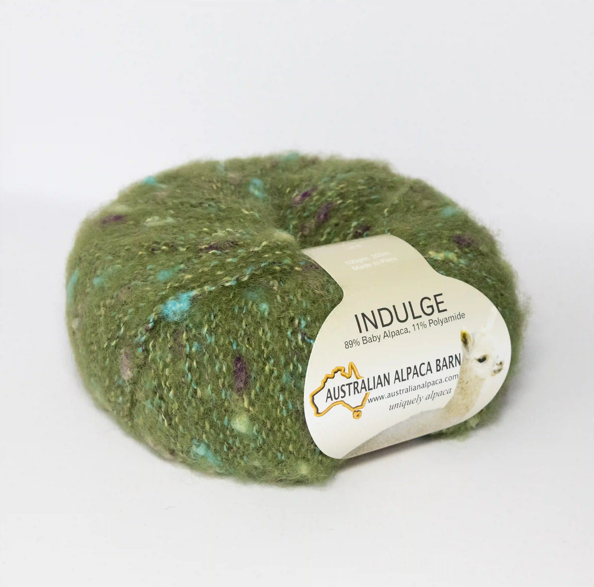 Moss Green Indulge baby alpaca bouclé yarn with its product label visible.