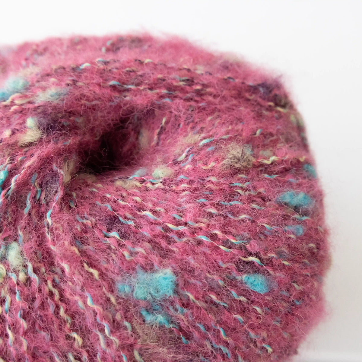 Close-up of Pink Indulge baby alpaca bouclé yarn showing its looped texture.