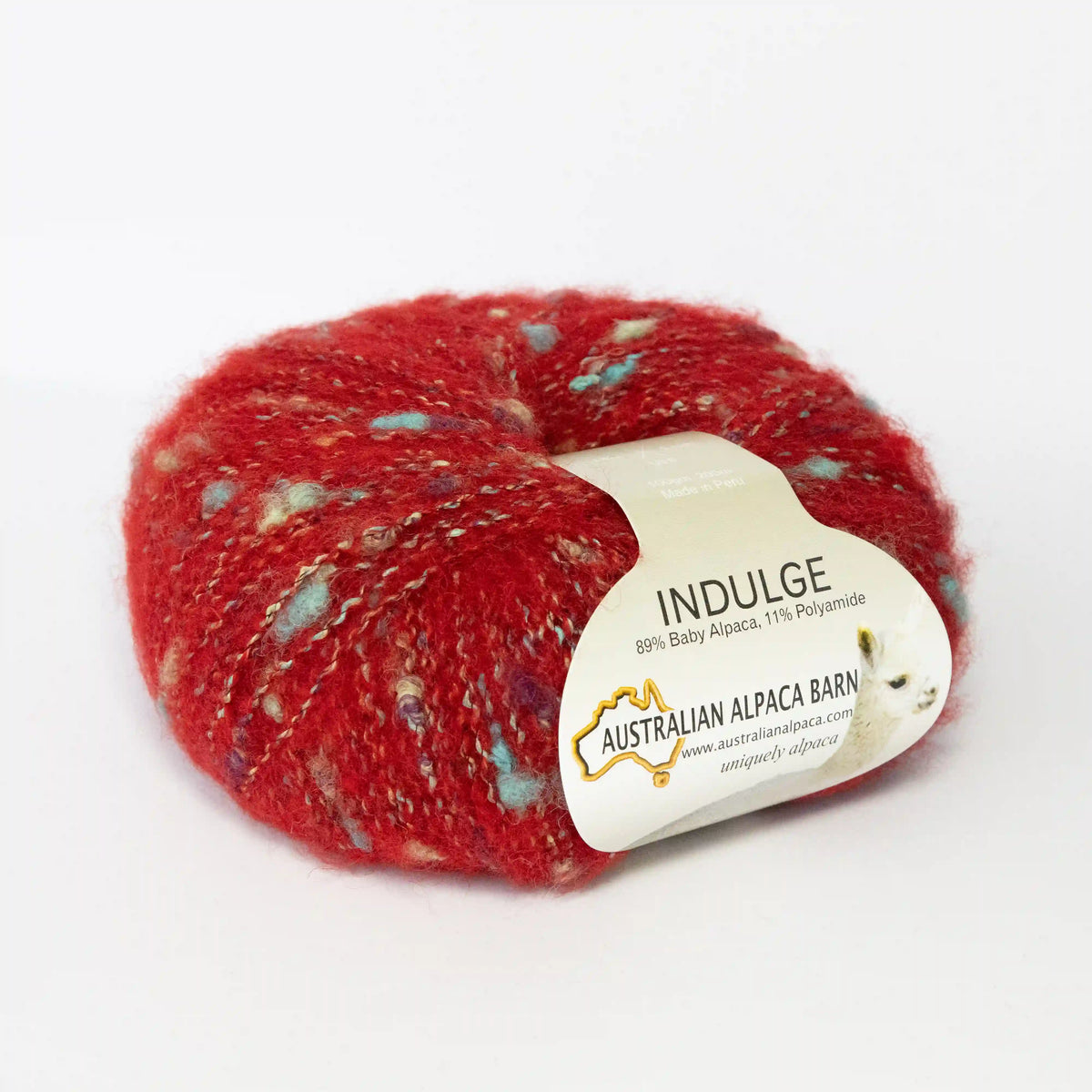 Red Indulge baby alpaca bouclé yarn with its product label visible.