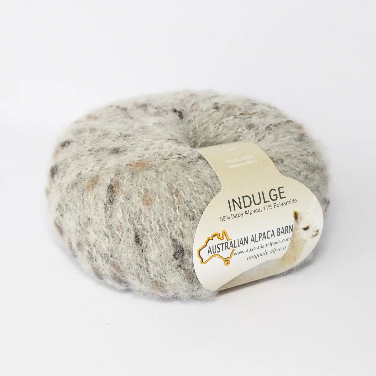 Silverwhite Indulge baby alpaca bouclé yarn with its product label visible.