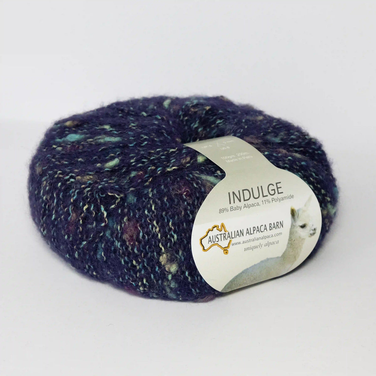 Navy Indulge baby alpaca bouclé yarn with its product label visible.