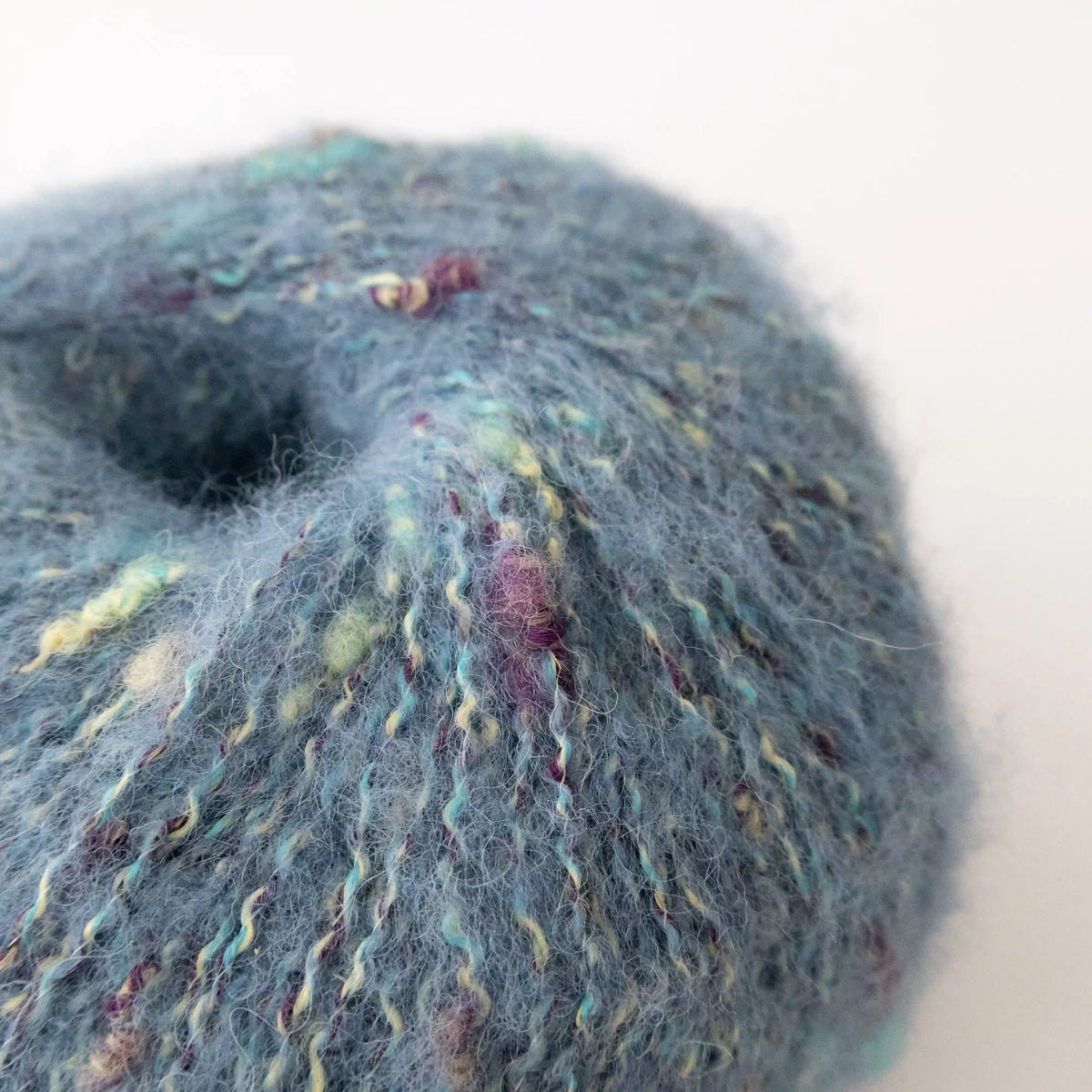 Close-up of Aqua Indulge baby alpaca bouclé yarn showing its looped texture