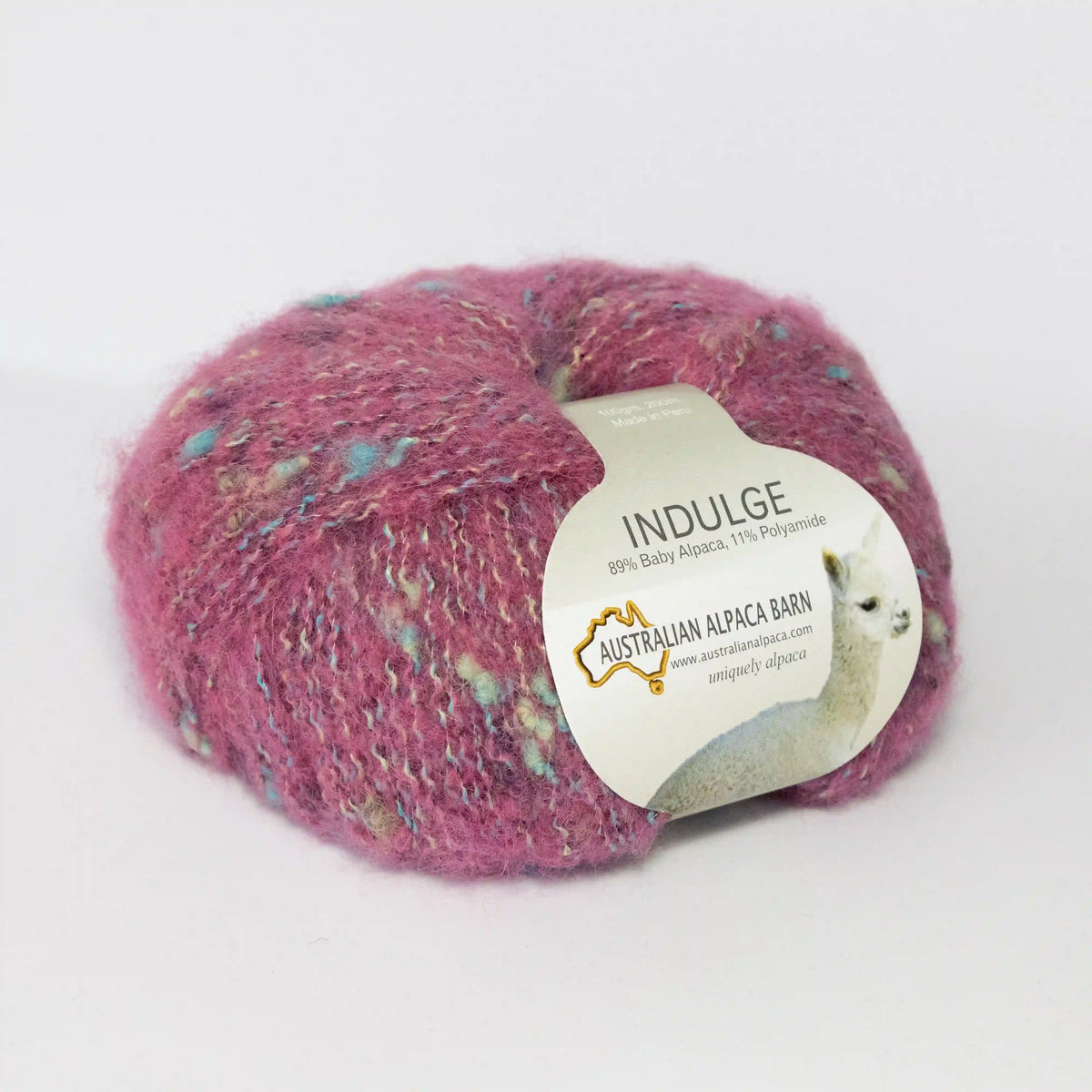 Pink Indulge baby alpaca bouclé yarn with its product label visible.